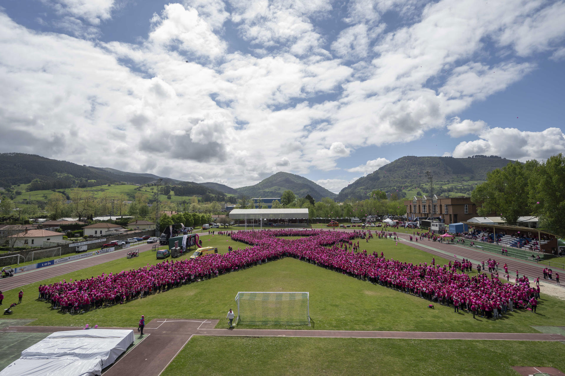 Más de 7.000 personas se han unido este domingo en el municipio cántabro de Los Corrales de Buelna para formar un lazo rosa contra el cáncer, que no ha conseguido batir el récord Guinness que ostenta Arabia Saudí con 8.264 participantes. EFE/Pedro Puente Hoyos