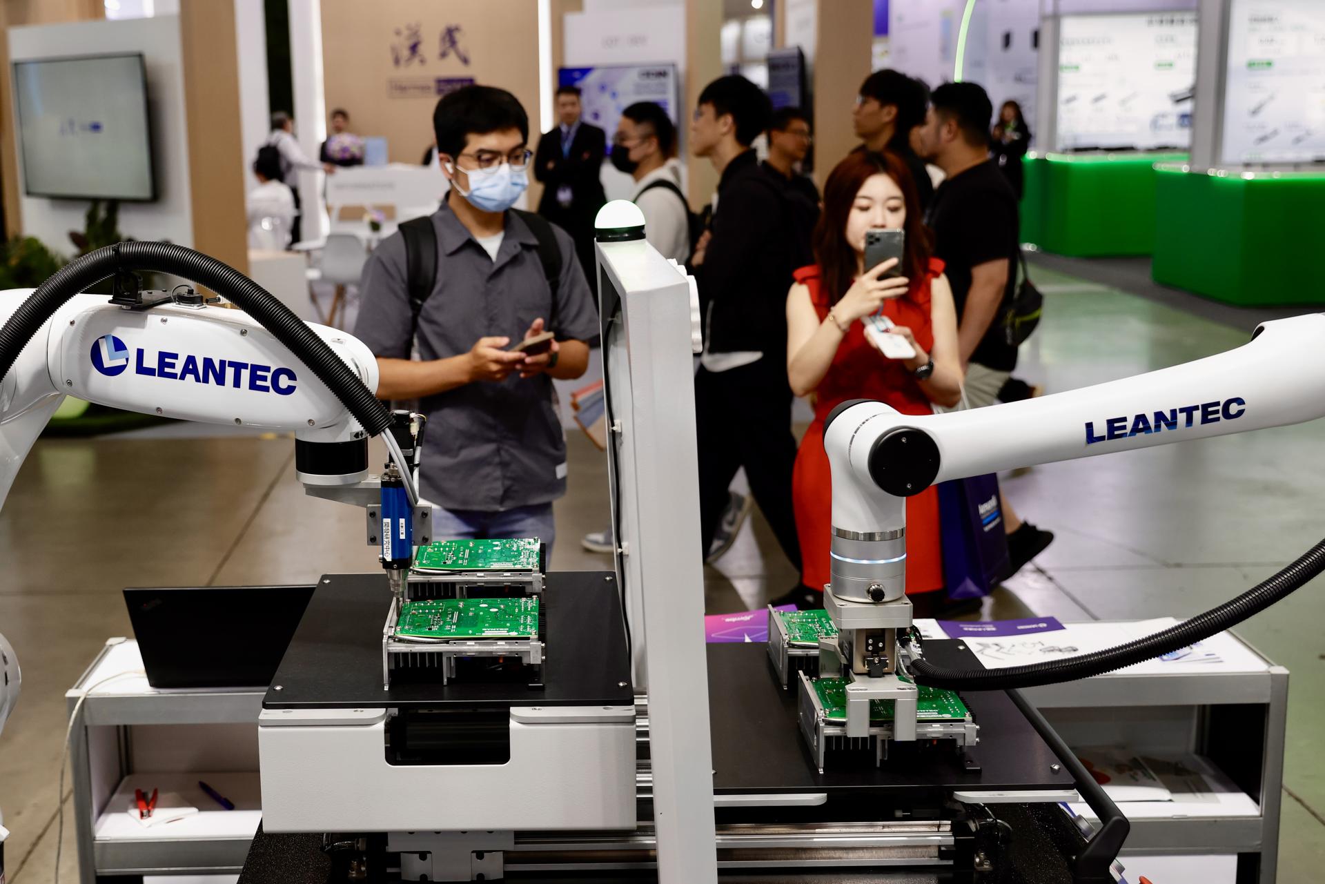 TAIPEI (Taiwan), 18/04/2025.- Gente observa brazos robóticos durante la Smart Manufacturing Expo en Taipei, Taiwán, en la que se muestran las últimas innovaciones en fabricación inteligente. EFE/EPA/RITCHIE B. TONGO