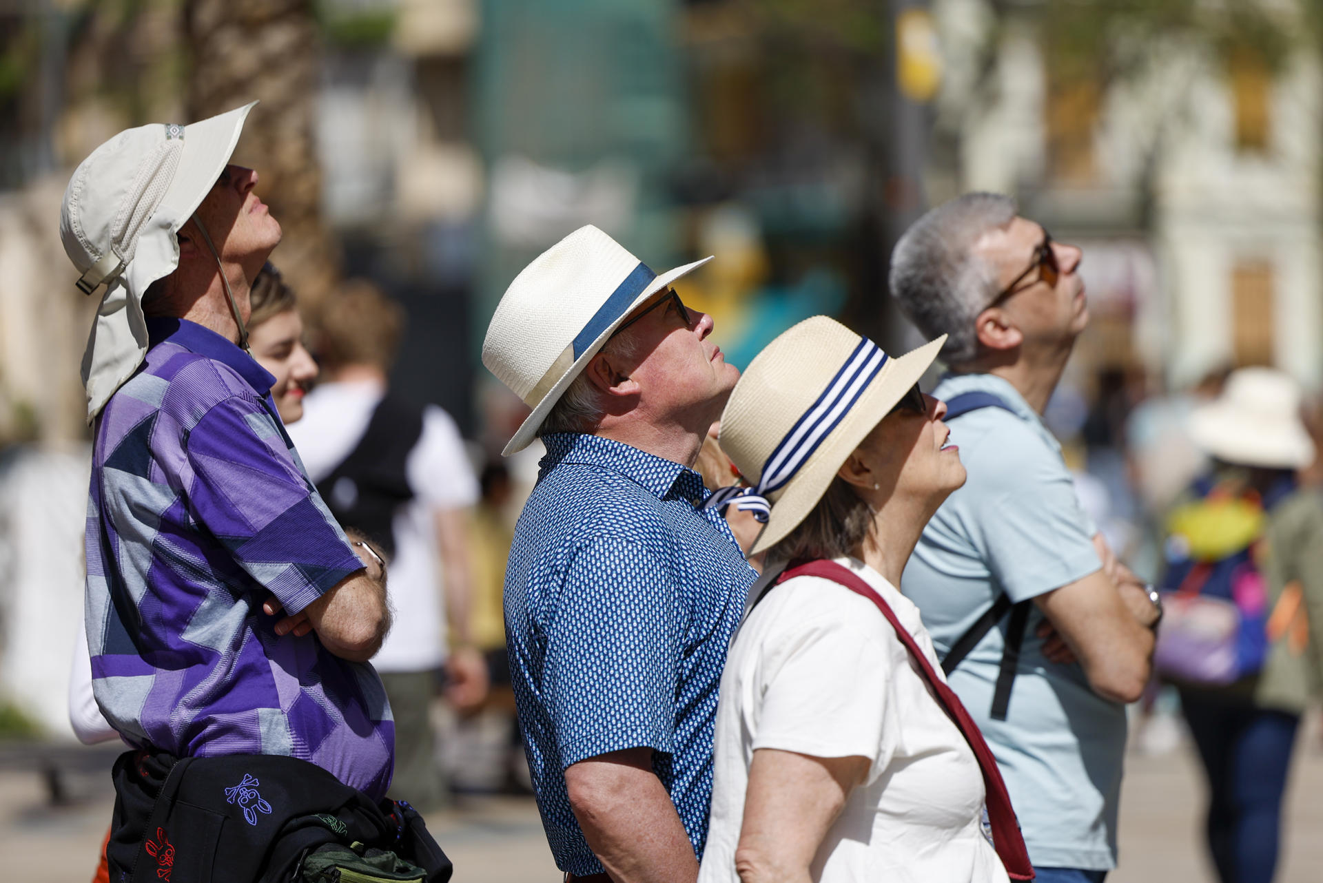 Varios turistas recorren la ciudad de Valencia protegidos con sombreros este lunes. EFE/Ana Escobar