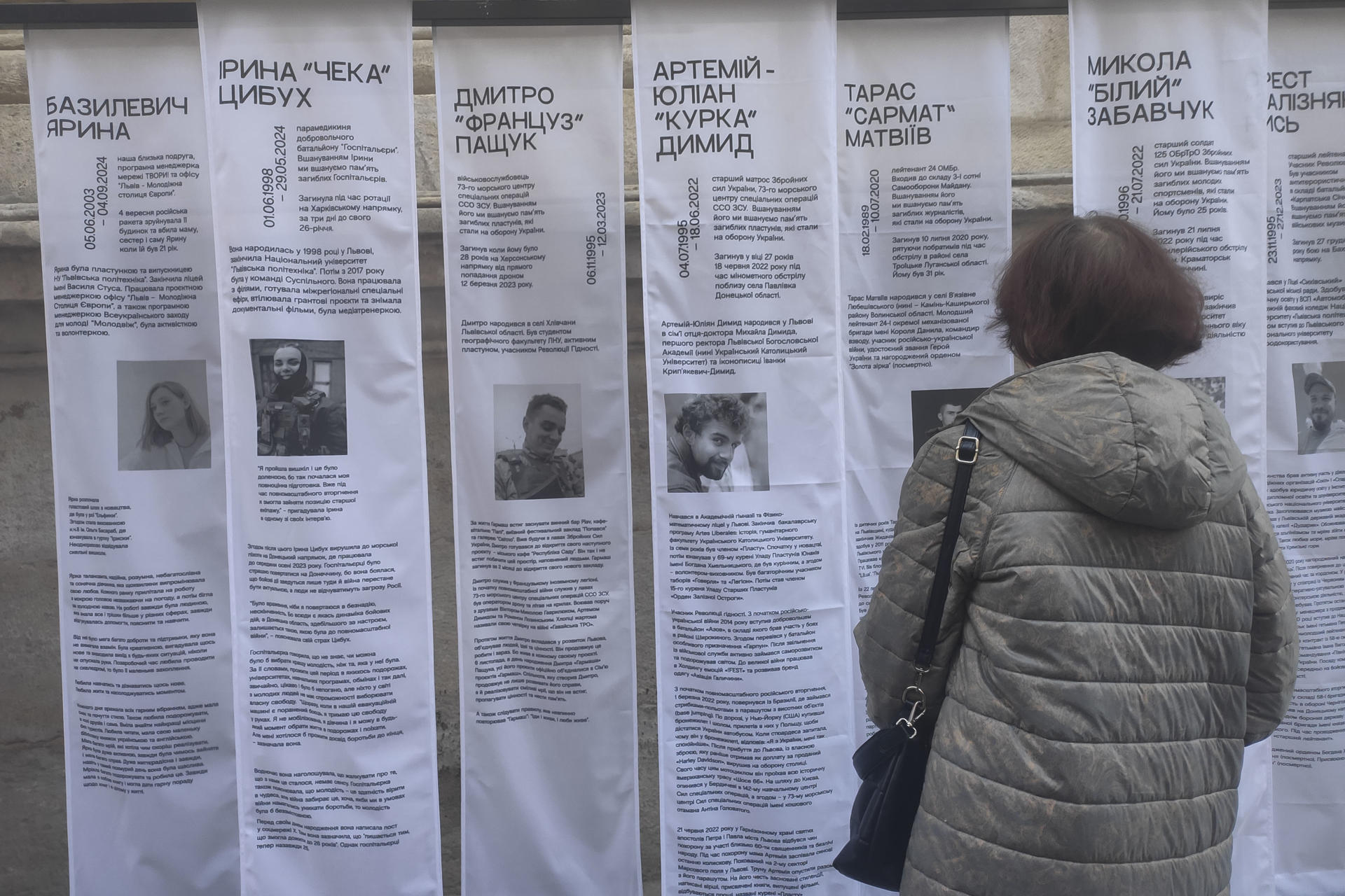 Una mujer observa las referencias a jóvenes ucranianos muertos en la guerra, durante el acto que marca Leópolis como capital simbólica de la juventud europea. EFE/ Rotyslav Averchuk