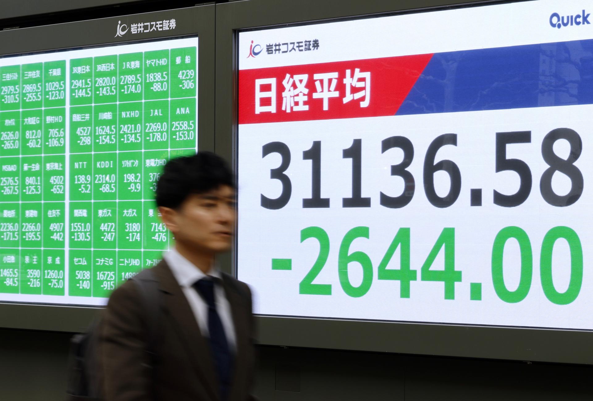 TOKIO (Japón), 07/04/2025.- Un hombre camina junto al indicador (el Nikkei) de la Bolsa de Tokio, Japón este lunes. EFE/ Franck Robichon