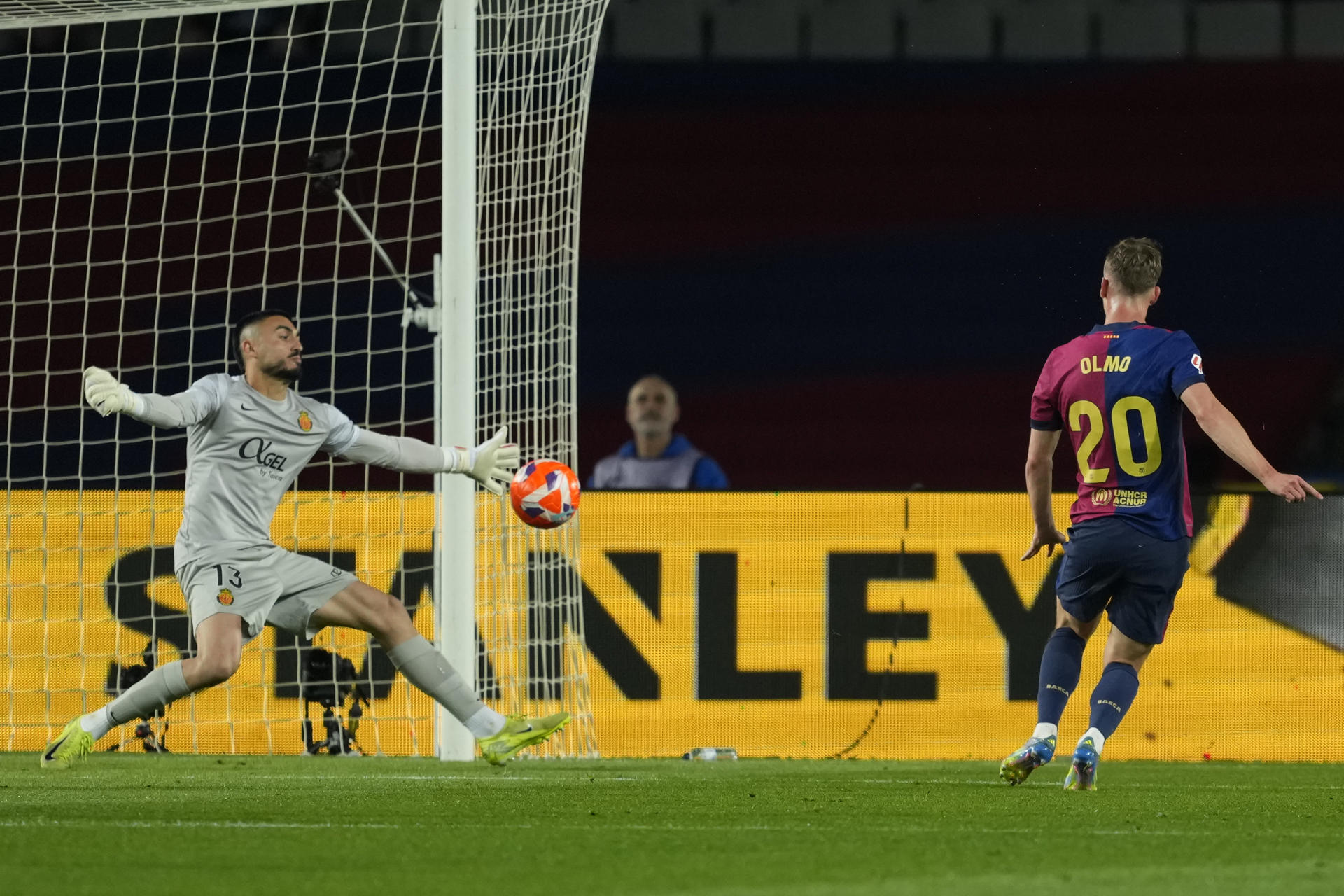 El delantero de FC Barcelona Dani Olmo (d) dispara a puerta ante Leo Román, guardameta del RCD Mallorca, durante el partido de la jornada 33 de LaLiga. EFE/Alejandro García