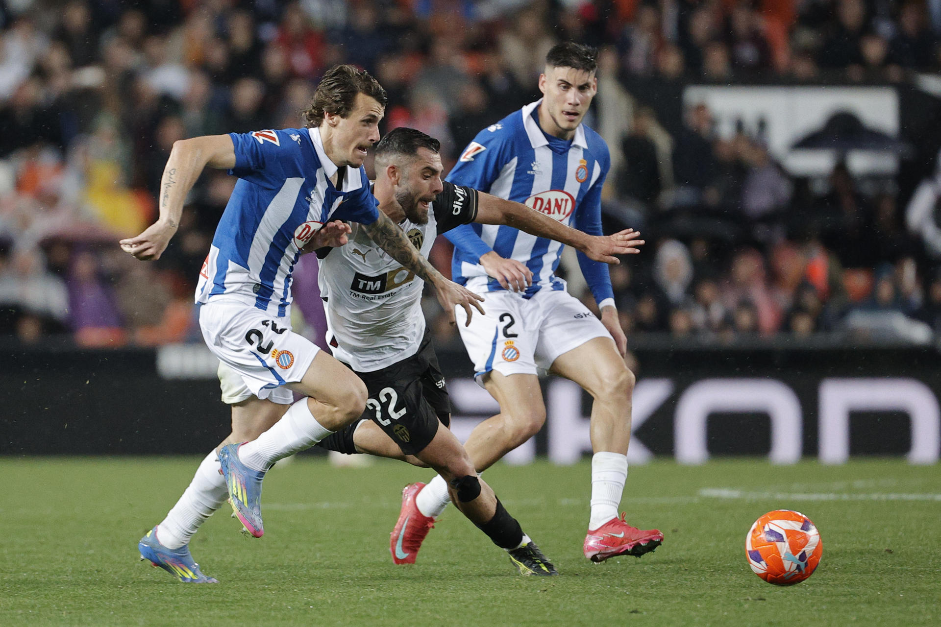 El delantero del Valencia Luis Rioja (c) trata de jugar un balón entre Crlos Romero (i) y Roberto Fernández, ambos del Espanyol, durante el partido de la jornada 33 de LaLiga EA Sports que Valencia CF y el RCD Espanyol disputaron en el estadio de Mestalla. EFE/Manuel Bruque