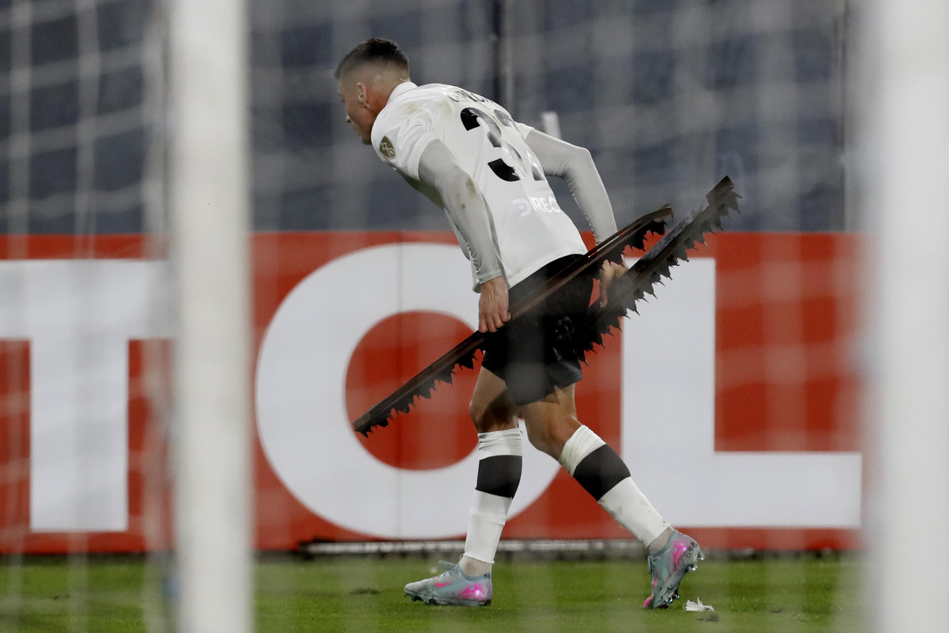 Lucas Cepeda de Colo Colo recoge objetos lanzados por aficionados al campo en un partido de la fase de grupos de la Copa Libertadores. EFE/ Osvaldo Villarroel
