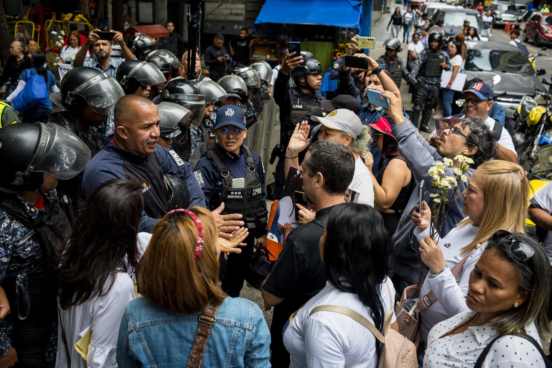 Personas hablan con integrantes de la policía durante una manifestación este martes en Caracas (Venezuela). EFE/ Miguel Gutiérrez