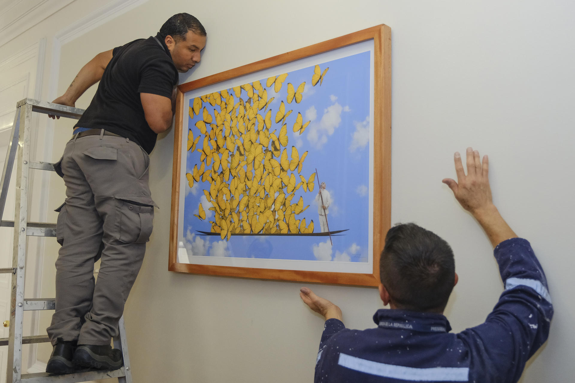 Fotografía cedida por la Presidencia de Colombia que muestra a dos trabajadores instalando la exposición 'Gabo vive en la Casa de Nariño', en Bogotá. EFE/ Presidencia de Colombia
