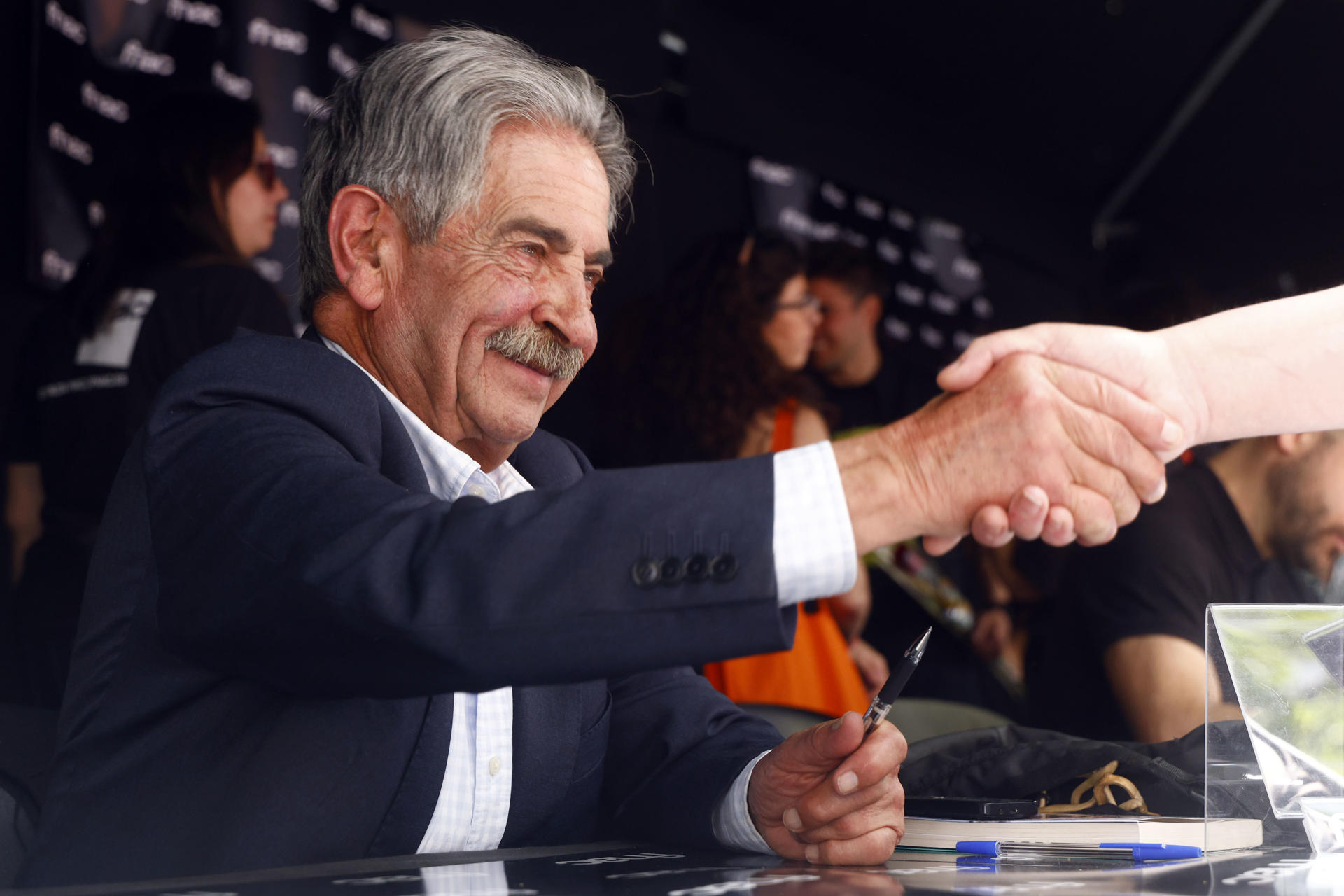 El expresidente de Cantabria Miguel Ángel Revilla firma libros durante la Diada de Sant Jordi, en la que los catalanes toman las calles a la búsqueda de libros y rosas para regalar a sus seres queridos y allegados. EFE/Quique García