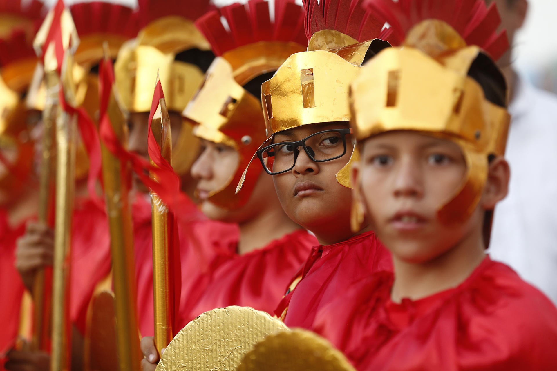 Un grupo de estudiantes de la escuela parroquial Domingo Savio personifican a un escuadrón de soldado romano, durante una recreación del Vía Crucis, en San Salvador (El Salvador). EFE/Rodrigo Sura