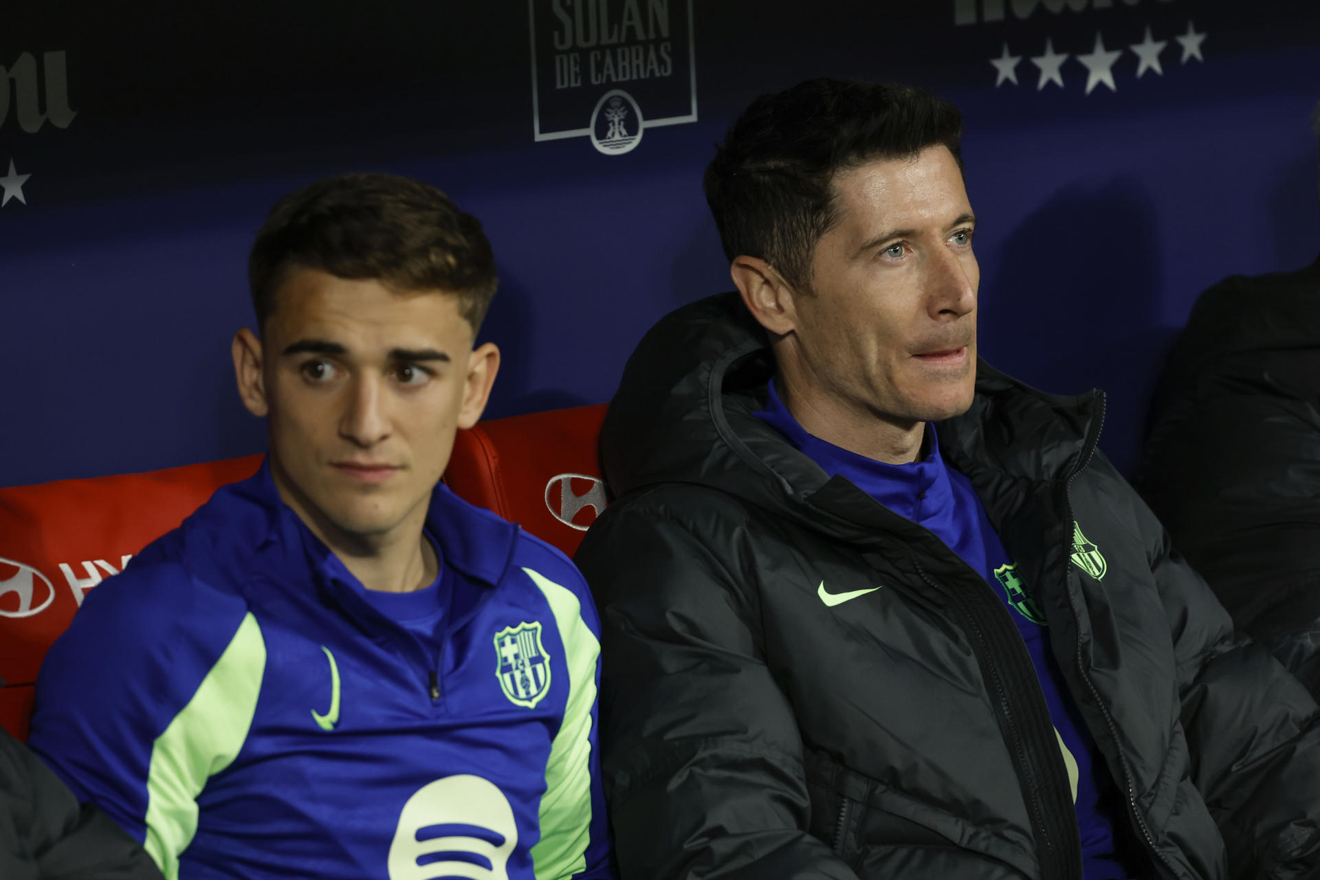 Los jugadores del FC Barcelona, Gavi (i) y el polaco Robert Lewandowski, en el banquillo durante el encuentro correspondiente a la vuelta de las semifinales de la Copa del Rey que disputan hoy miércoles Atlético de Madrid y FC Barcelona en el estadio Metropolitano, en Madrid. EFE / Juanjo Martín.