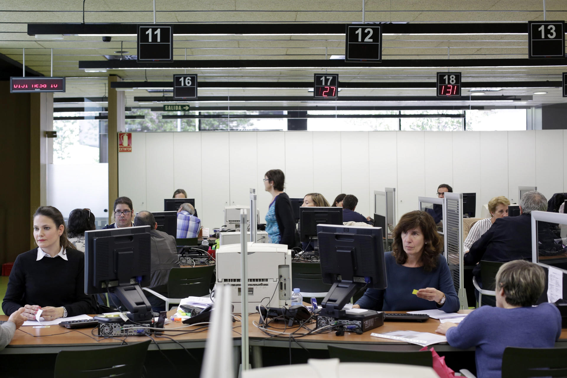Varios contribuyentes realizan su declaración de la renta en una oficina de Hacienda en Pamplona. EFE/Villar López