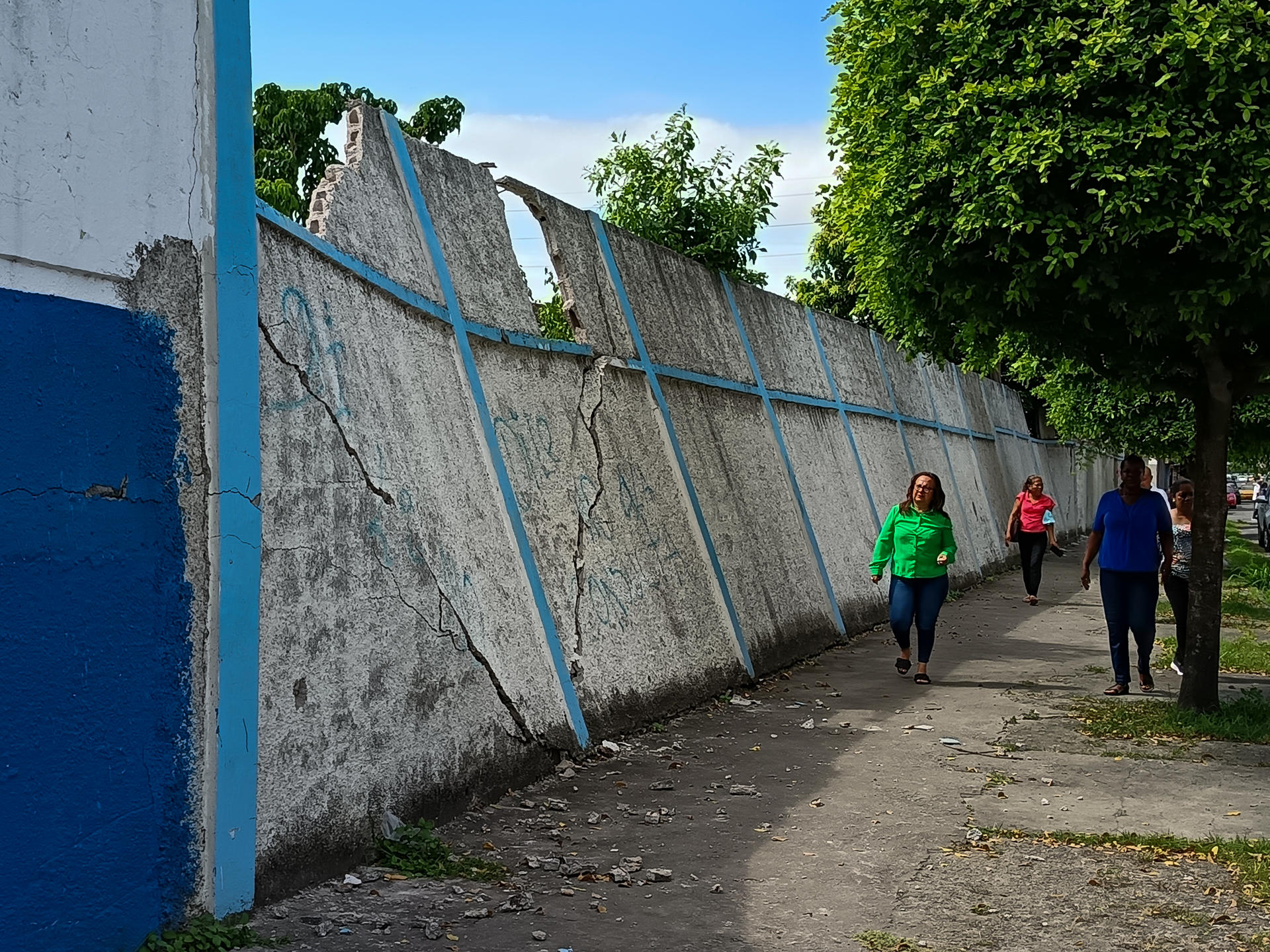 Personas caminan frente a un muro con daños estructurales este viernes, en Esmeraldas (Ecuador). EFE/ Jorge Demera

