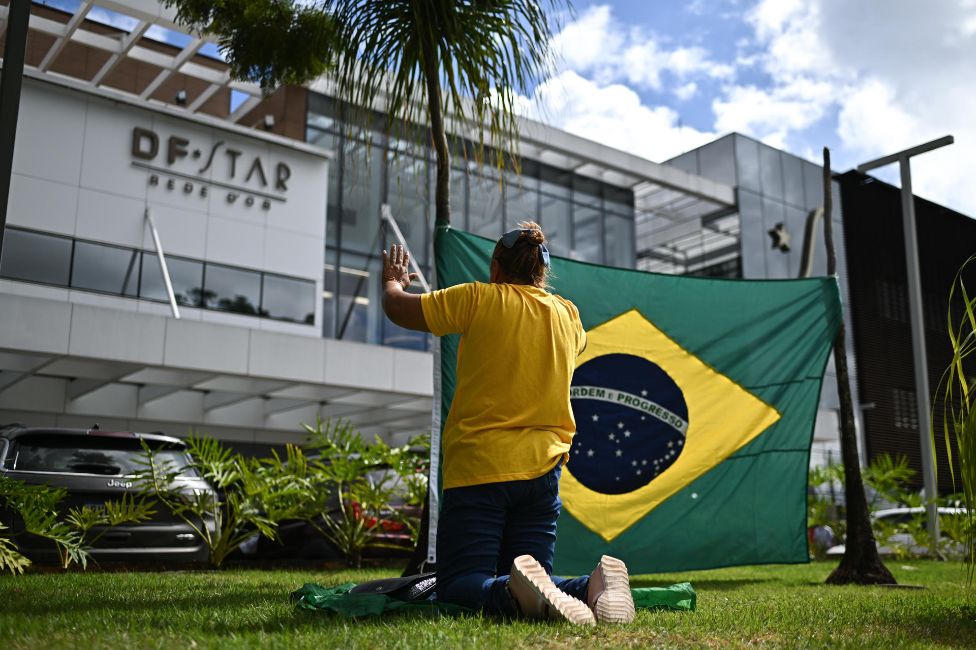 Una simpatizante del expresidente de Brasil Jair Bolsonaro reza frente al Hospital DF Star, donde se encuentra el exmandatario, este lunes en Brasilia (Brasil). EFE/ Andre Borges