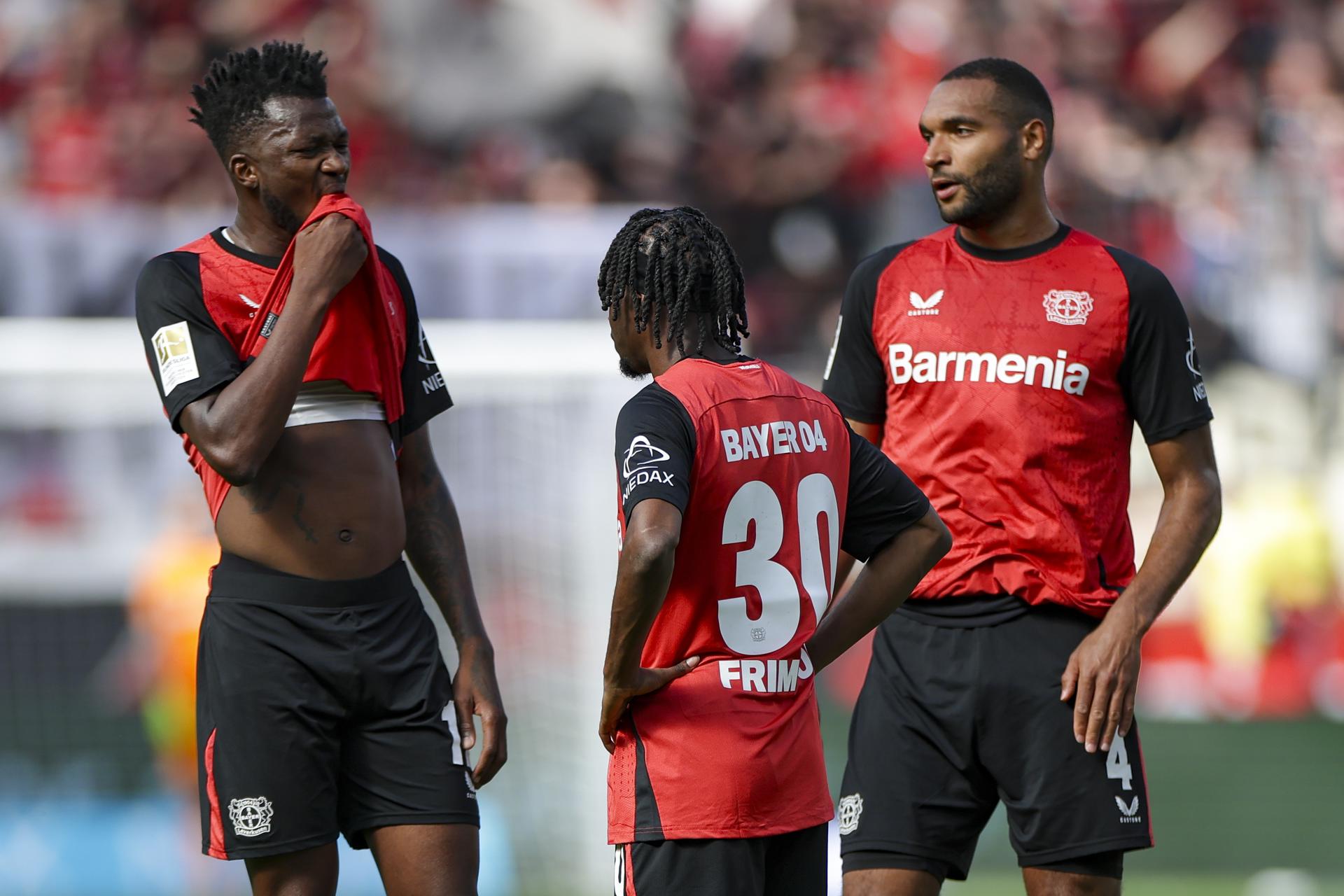 (I-D) Edmond Tapsoba, Jeremie Frimpong, y Jonathan Tah, todos del Leverkusen, se lamentan durante el partido de la Bundesliga que han jugado Bayer 04 Leverkusen y 1.FC Union Berlin, en Leverkusen, Alemania. EFE/EPA/CHRISTOPHER NEUNDORF