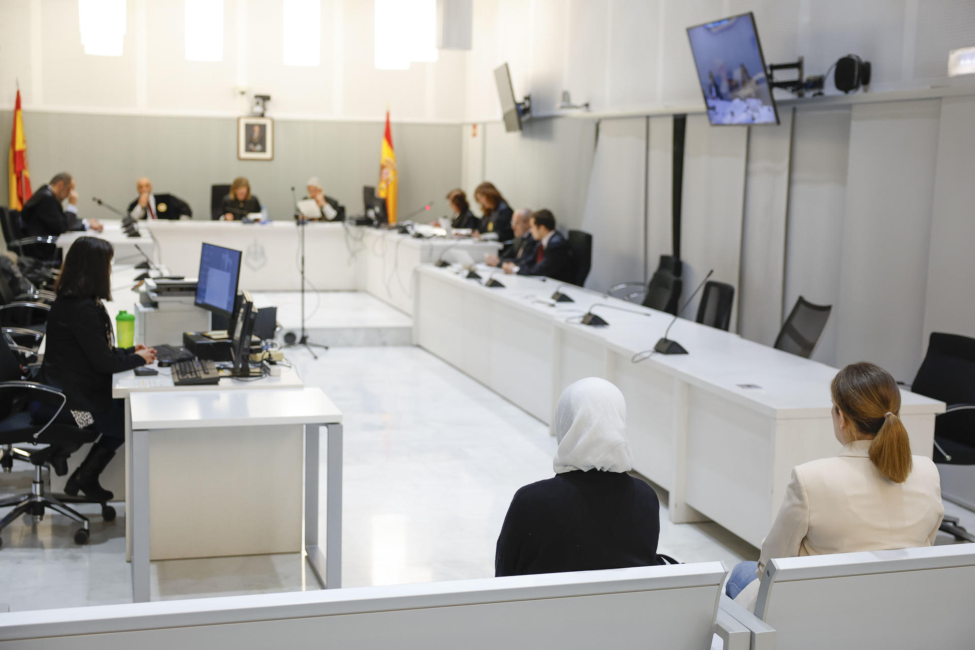 Las dos españolas casadas con yihadistas y repatriadas desde Siria en enero de 2023, Yolanda Martinez Cobos (d) y Luna Fernández Grande (i) este lunes durante el juicio en su contra en la Audiencia Nacional en Marid donde previsiblemente aceptarán una condena de tres años de cárcel a cambio de reconocer su integración en organización terrorista al desplazarse "voluntariamente" con sus maridos a la zona del Dáesh y acogerse a sus postulados. EFE/ Mariscal / POOL