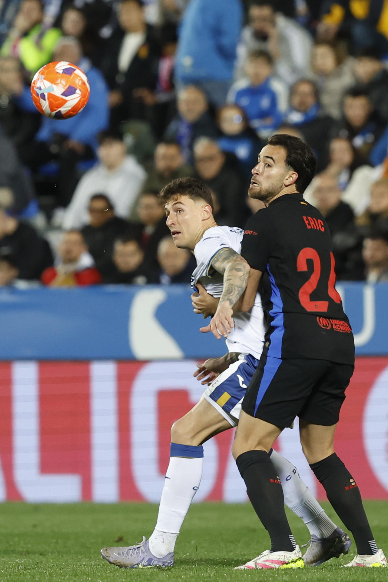 El delantero del Leganés Dani Raba disputa un balón ante el defensa del Barcelona Eric García (d), durante el partido de la jornada 31 de LaLiga EA Sports que CD Leganés y FC Barcelona disputaron en el estadio de Butarque. EFE/Juan Carlos Hidalgo