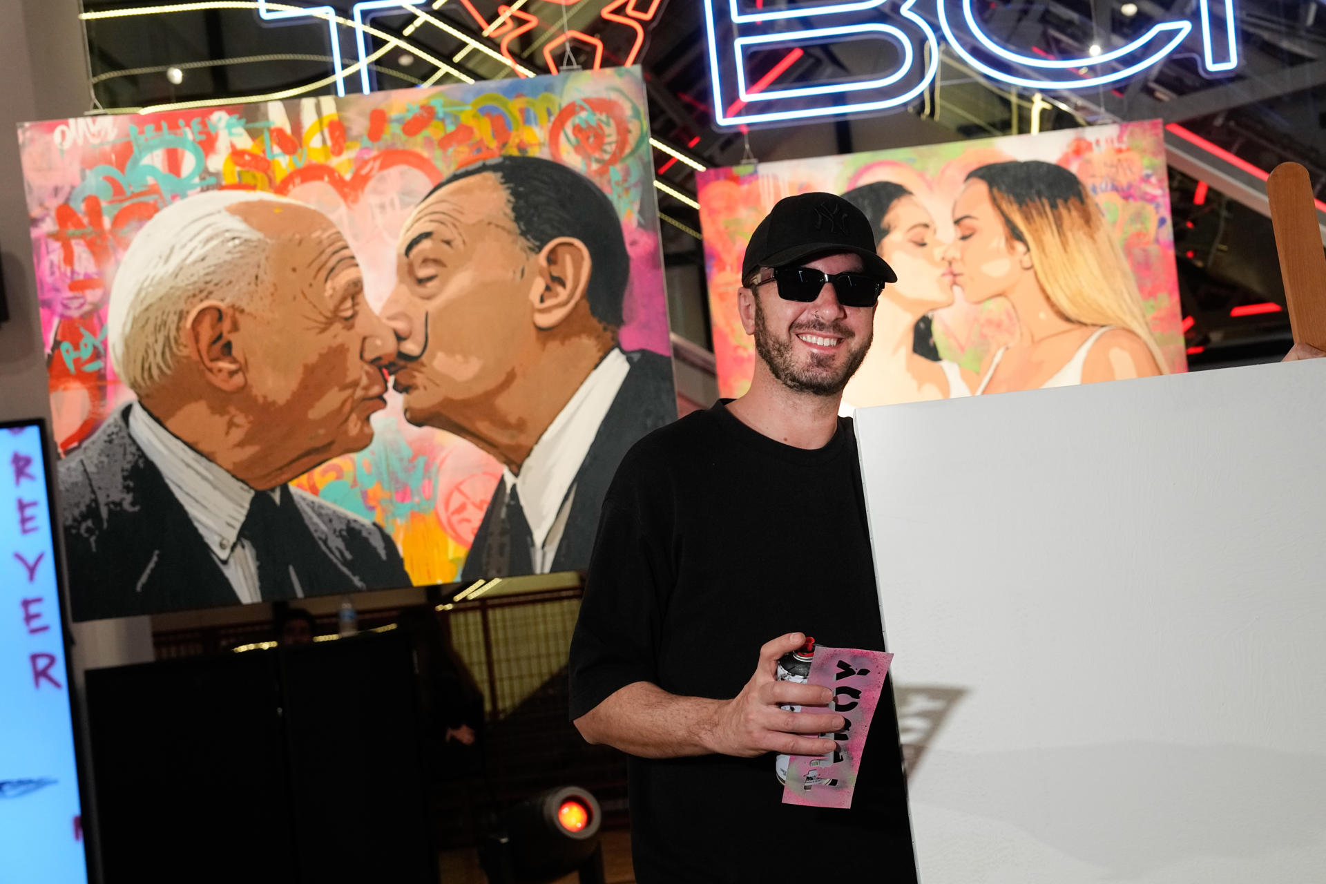 La sede de Casa Seat Barcelona acoge desde este lunes la exposición ‘Besos Prohibidos’ del artista urbano TVBoy, una selección de osculos "inesperados" entre figuras públicas, como Rosalía y Bad Gyal, Meghan Markle y Kate Middleton, o Pablo Motos y David Broncano. EFE/Enric Fontcuberta
