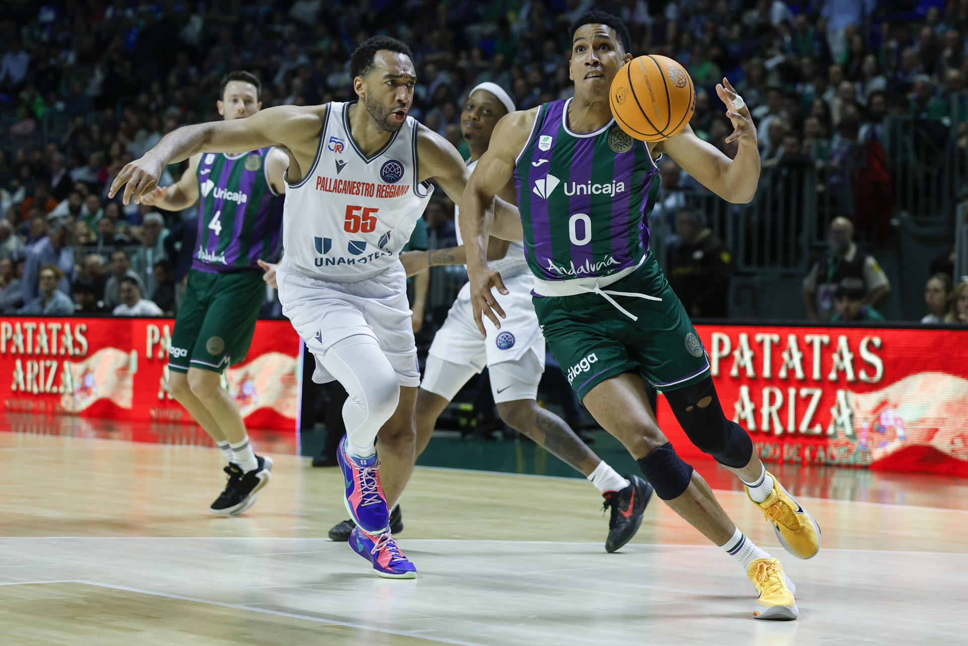 El alero del Unicaja Tyson Pérez en acción ante el alero estadounidense de Reggiana Kwan Cheatham (c), durante el encuentro correspondiente a los cuartos de final de la Liga de Campeones que disputaron Unicaja y Reggiana en el pabellón Martín Carpena de Málaga. EFE / Jorge Zapata.
