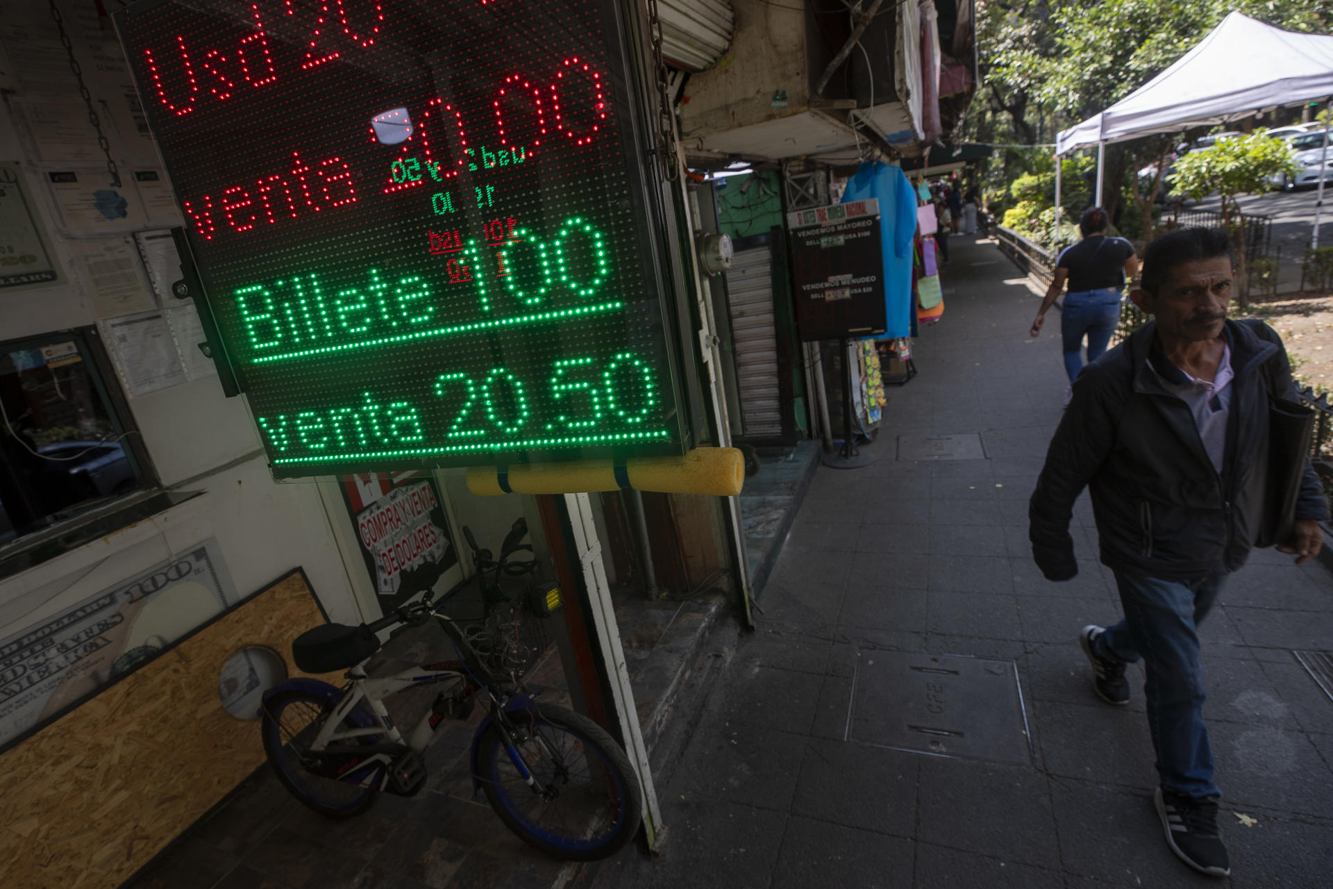 Personas caminan frente a una casa de cambio en Ciudad de México (México), en una fotografía de archivo. La relación de América Latina con el dólar estadounidense es diversa y, en muchos casos, contradictoria. Mientras algunos países han adoptado formalmente la divisa como moneda de curso legal, otros viven en un régimen de bimonetarismo de facto, donde el dólar reina en la economía cotidiana sin figurar oficialmente. EFE/ Isaac Esquivel