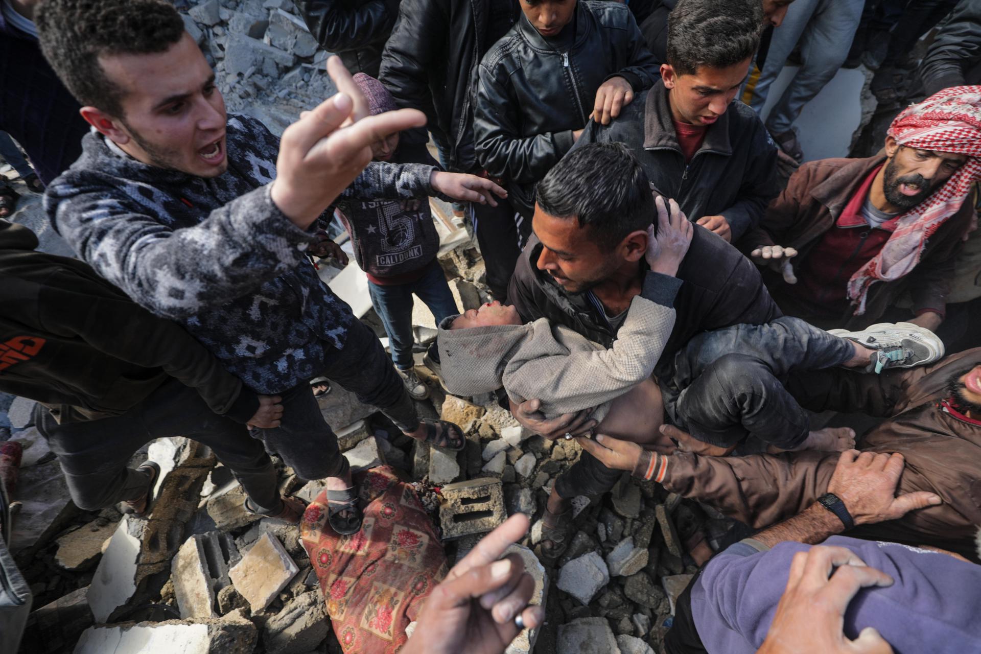 Palestinos recuperan a un niño herido entre los escombros de una casa destruida tras un ataque aéreo israelí en la localidad de Deir Al Balah, al sur de la Franja de Gaza, el 18 de febrero de 2024. EFE/EPA/MOHAMMED SABLE