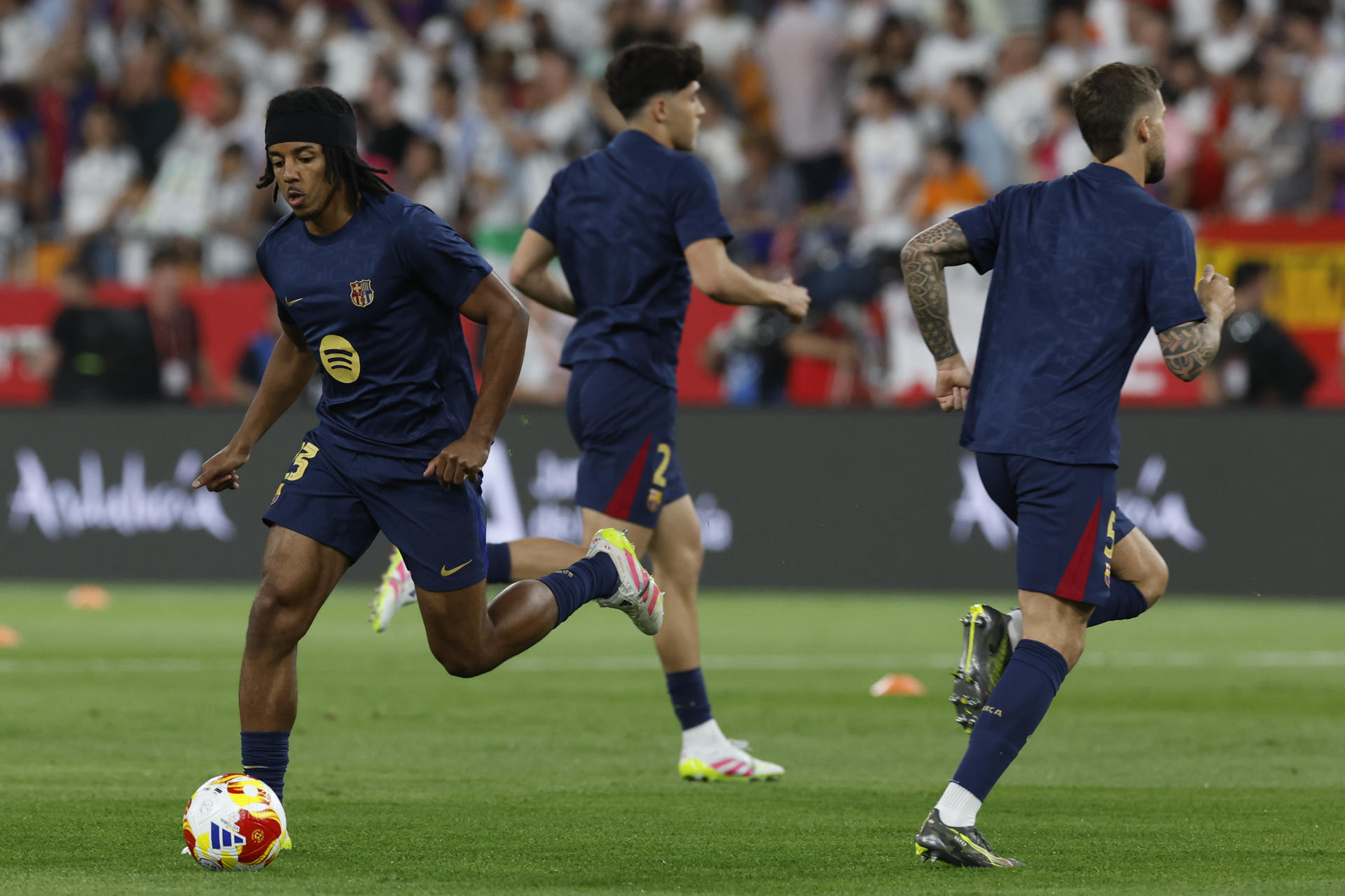 El defensa del FC Barcelona Jules Koundé (i) durante el calentamiento previo a la final de la Copa del Rey que disputan Real Madrid y FC Barcelona en el estadio de La Cartuja, en Sevilla. EFE / Julio Muñoz.