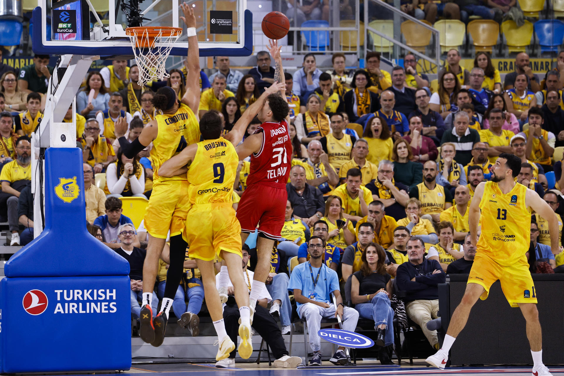 El jugador del Hapoel Tel Aviv, Noam Yaacov (d), entra a canasta ante los defensores de Gran Canaria durante el segundo partido de la final de la Eurocopa que Dreamland Gran Canaria y Hapoel Tel Aviv disputan este viernes en Las Palmas. EFE/Elvira Urquijo