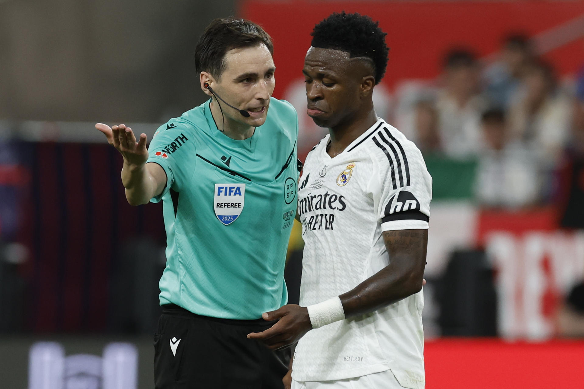 El delantero brasileño del Real Madrid Vinicius Jr. (d) discute con el árbitro De Burgos Bengoetxea, durante la final de la Copa del Rey que disputaron Real Madrid y FC Barcelona en el estadio de La Cartuja, en Sevilla. EFE/Julio Muñoz