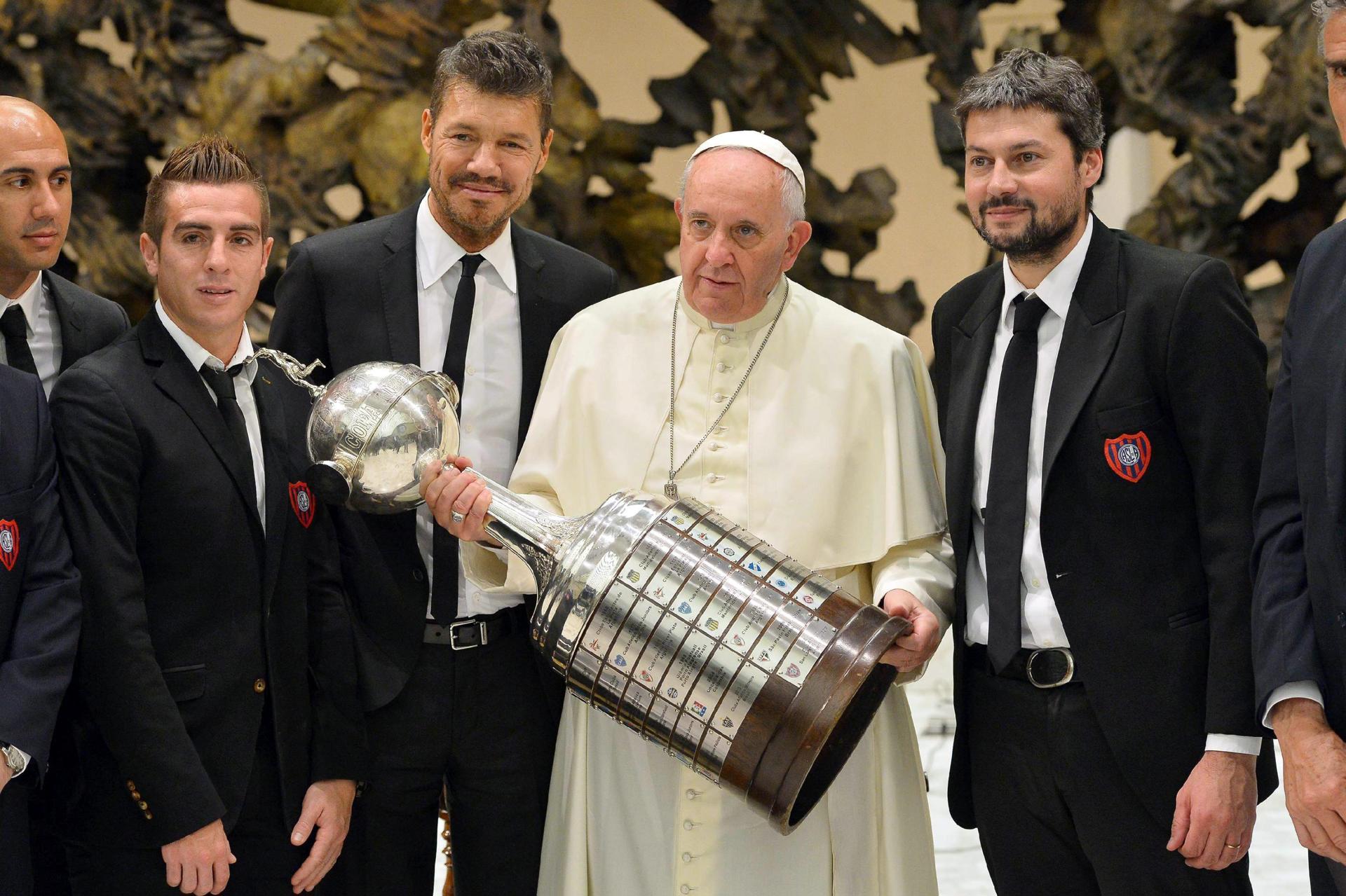 Fotografía facilitada por el Observador Romano que muestra al papa Francisco con el trofeo de la Copa Libertadores, rodeado de miembros del equipo San Lorenzo, que ganó en 2014 la Copa Libertadores. EFE/-