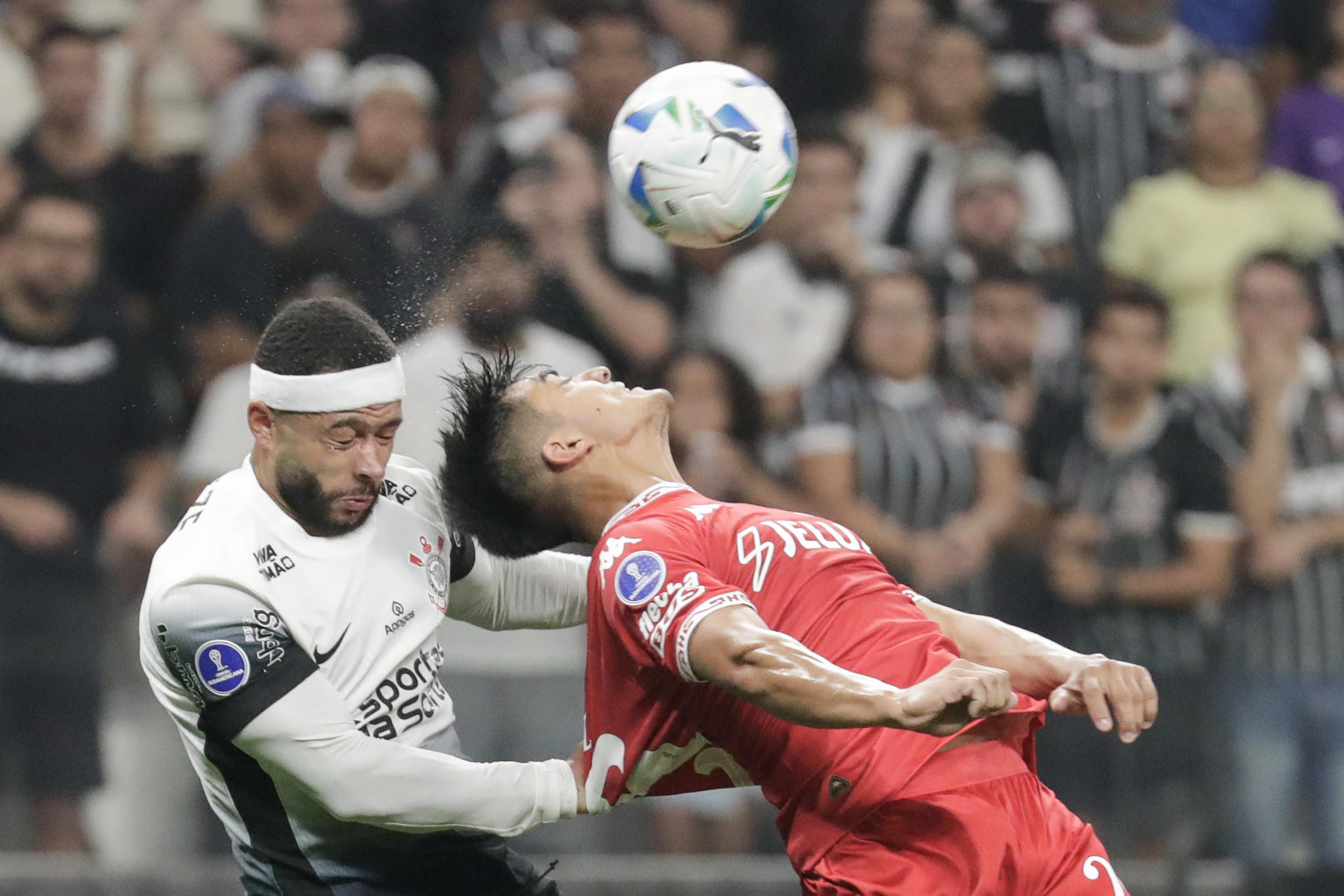 Memphis Depay (i) de Corinthians dispita un balón con César Román de Huracán en un partido de la fase de grupos de la Copa Sudamericana. EFE/ Sebastiao Moreira