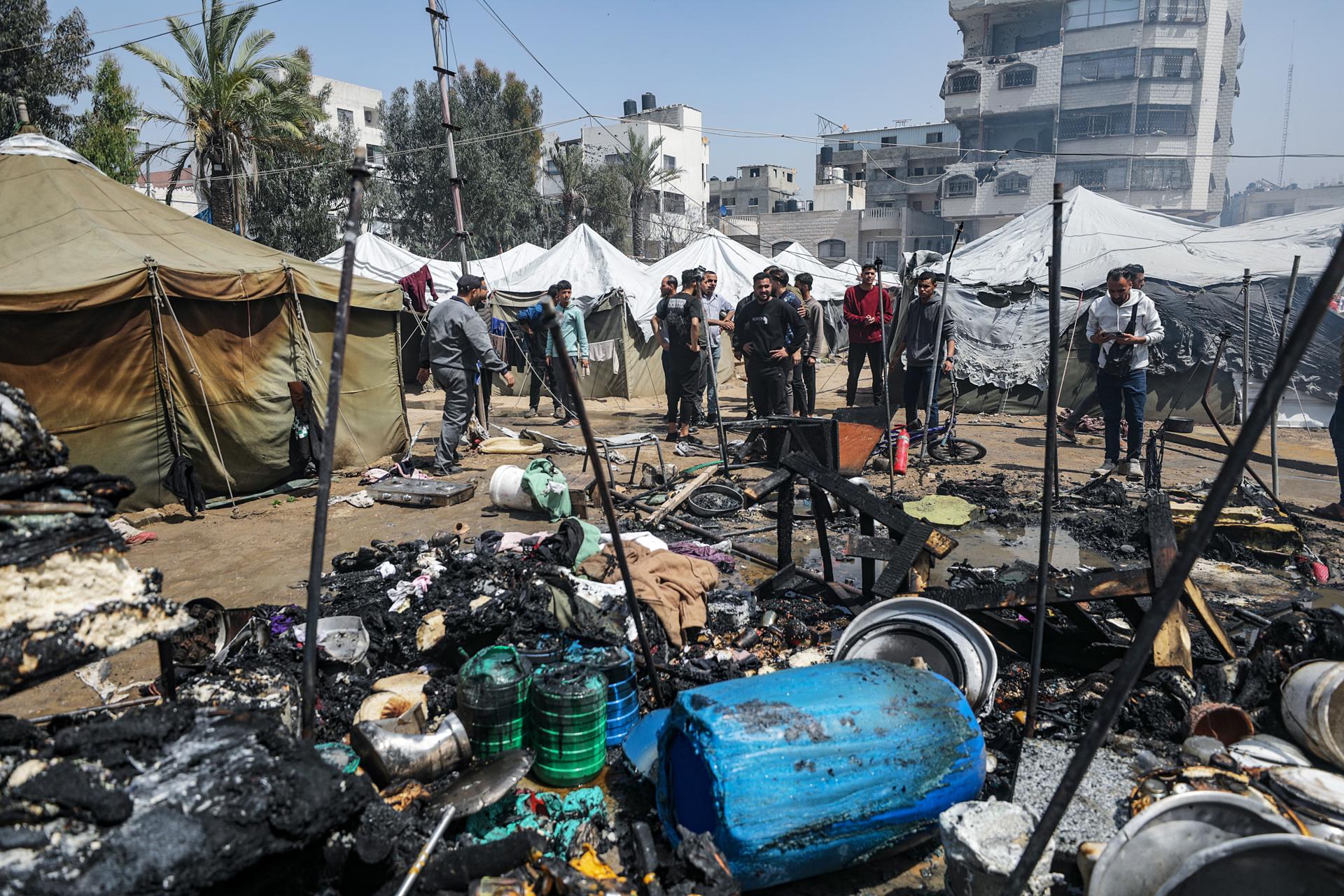 Unas  personas inspeccionan las tiendas destruidas de palestinos desplazados internos tras un ataque aéreo israelí en la Ciudad de Gaza, 21 de abril de 2025. EFE/EPA/MOHAMMED SABER