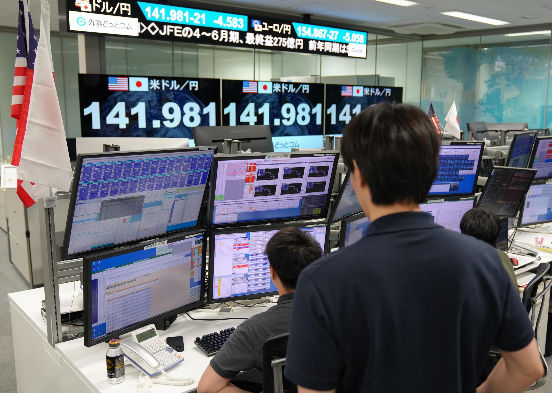 Fotografía de archivo que muestra a trabajadores de la Bolsa de Tokio frente a monitores. EFE/EPA/KIMIMASA MAYAMA