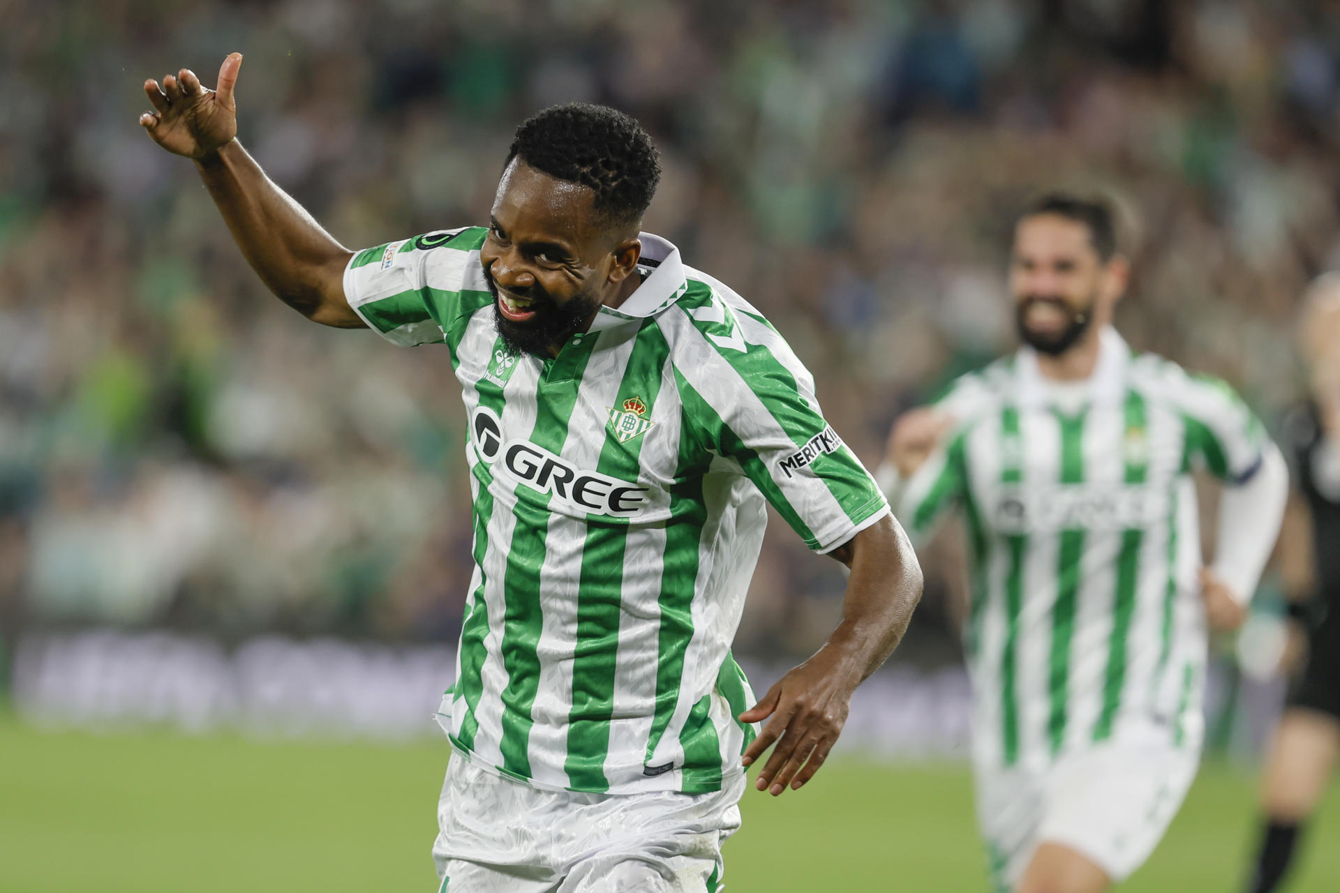 El delantero del Betis Cédric Bakambu celebra tras marcar ante el Jagiellonia Bialystok, durante el partido de ida de los cuartos de final de la Liga Conferencia que Real Betis y Jagiellonia Bialystok disputaron en el estadio Benito Villamarín, en Sevilla. EFE/José Manuel Vidal