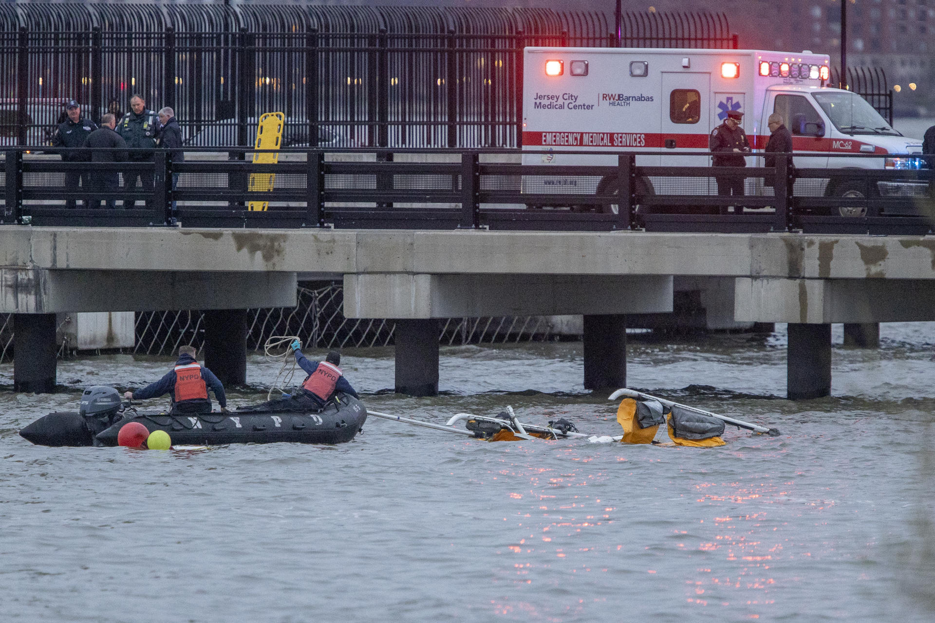 Personal de organismos de emergencia participan en las labores de rescate tras el accidente de un helicóptero este jueves, en el Río Hudson en Nueva York (Estados Unidos). Cinco españoles murieron al estrellarse un helicóptero en las aguas del río Hudson, según confirmó el alcalde de la ciudad, Eric Adams. Se trata de dos adultos y tres niños, al parecer de una misma familia, además del piloto. EFE/ Angel Colmenares
