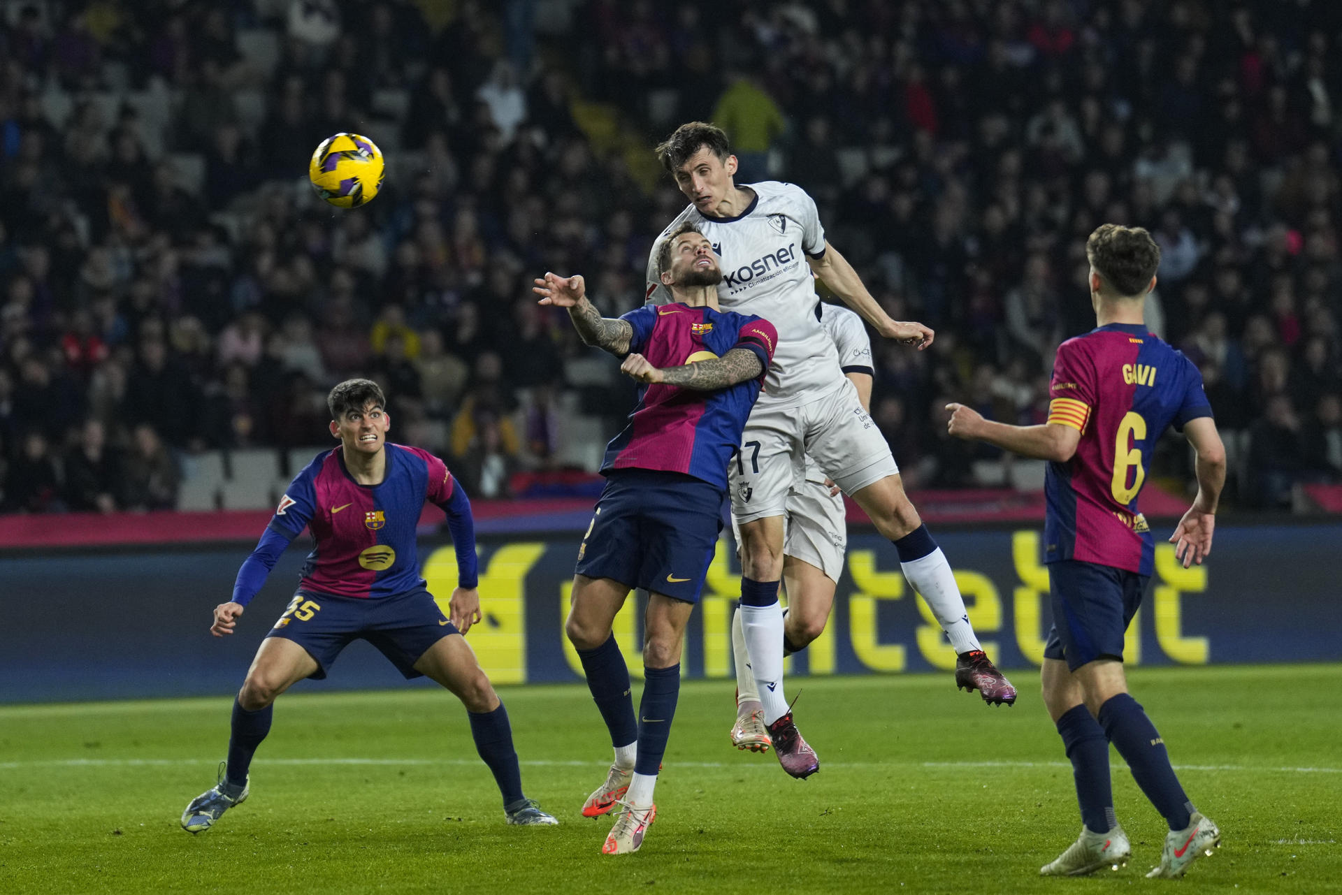 El delantero de Osasuna Ante Budimir (2d) remata de cabeza junto a Íñigo Martínez, del FC Barcelona, durante el partido de la jornada 27 de LaLiga que FC Barcelona y Atlético Osasuna disputaron en el Estadio Olímpico Lluís Companys. EFE/Alejandro García