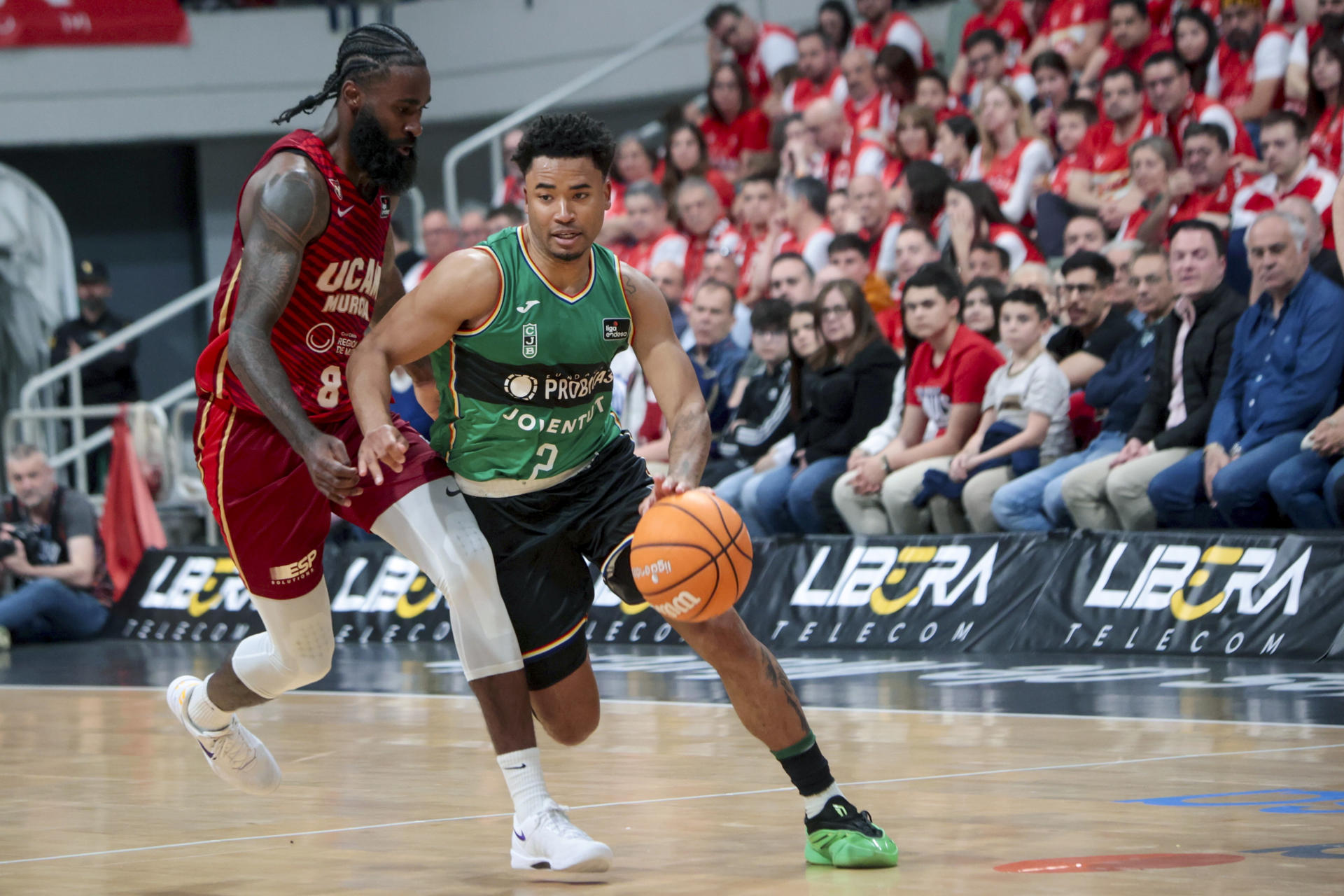 El base del Joventut Devon Dotson (d) se escapa de Sant-Roos, de UCAM Murcia, durante el partido correspondiente a la jornada 28 de la Liga Endesa, que disputaron en el Palacio de los Deportes de Murcia. EFE/Juan Carlos Caval