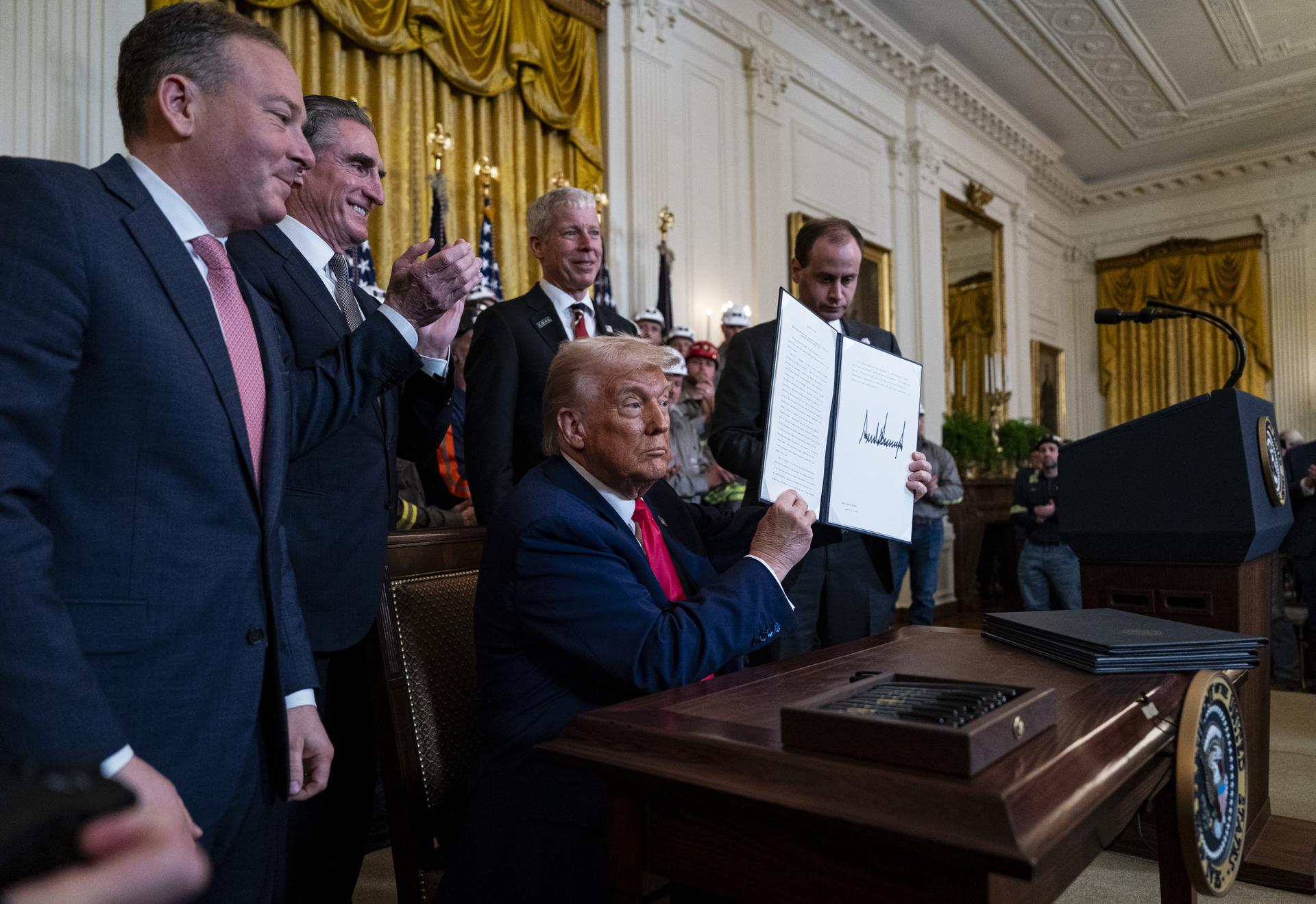 El presidente de EE. UU., Donald Trump (frente C), muestra un decreto ejecutivo firmado, en la Casa Blanca en Washington, DC, EE. UU., el 8 de abril de 2025 EFE/Al Drago / POOL