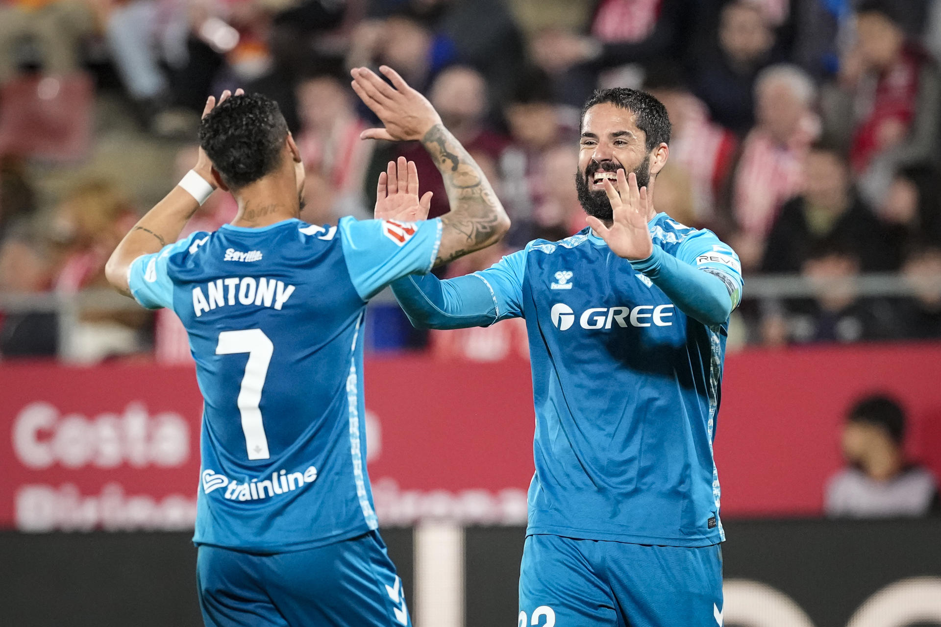 Los jugadores del Betis, el brasileño Antony (i) e Isco, celebran uno de los goles del equipo bético durante el encuentro correspondiente a la jornada 32 de Laliga EA Sports que disputaron Girona y Betis en el estadio de Montilivi, en Girona. EFE / David Borrat.