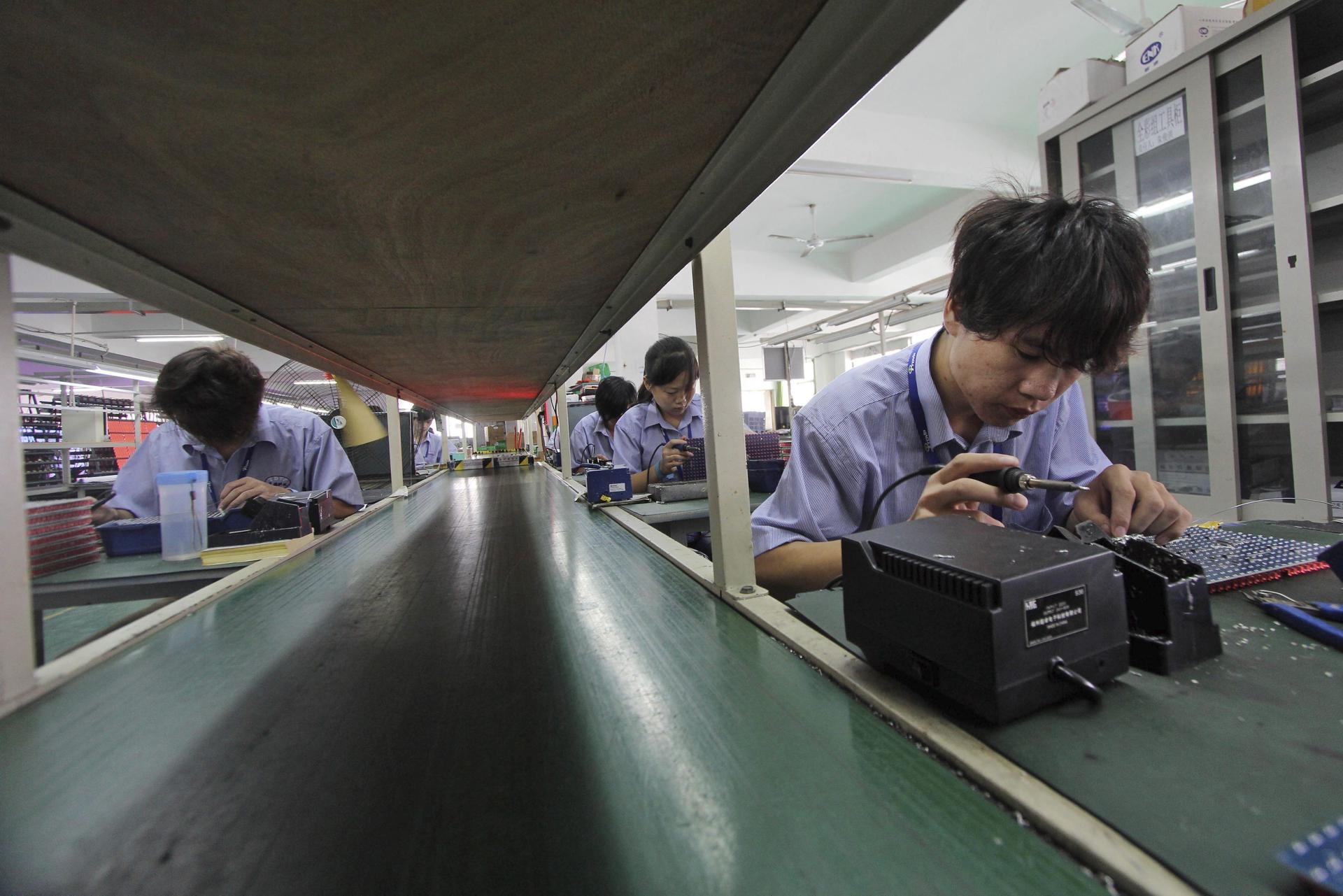 Trabajadores sueldan diodos emisores de luz en placas de circuitos en una fábrica que produce pantallas LED en la ciudad de Shishi, en la provincia de Fujian, al sureste de China EPA/HE YUAN CHINA OUT[CHINA OUT]