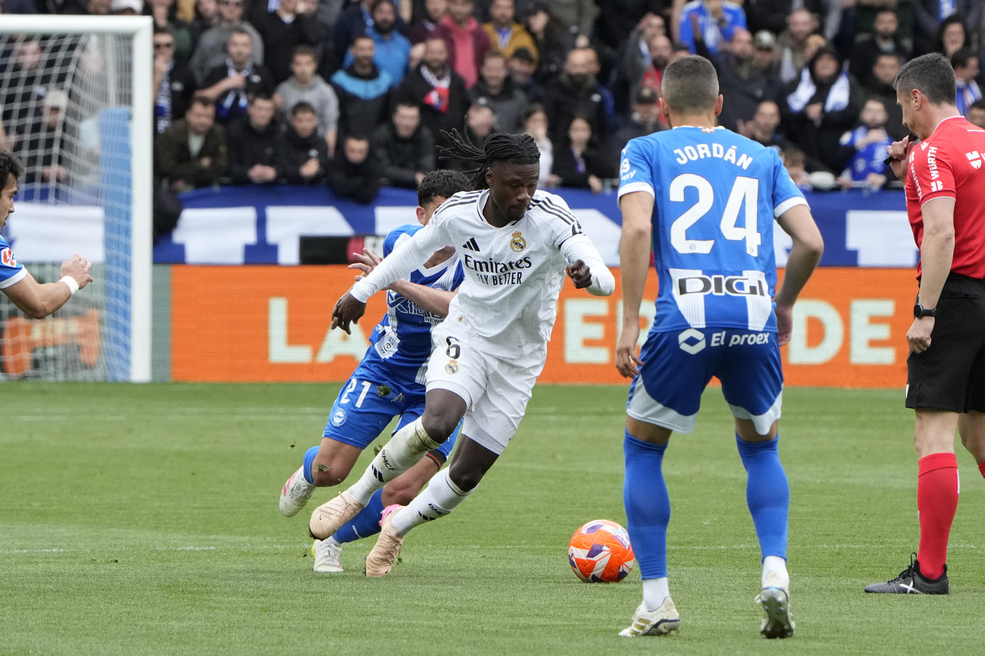 El centrocampista del Alavés Carles Aleñá (i) disputa un balón ante el centrocampista del Real Madrid Eduardo Camavinga (c) este domingo, durante el partido de la jornada 31 de LaLiga EA Sports, entre el Deportivo Alavés y Real Madrid, en el estadio de Mendizorrotza de Vitoria. EFE/ Adrian Ruiz Hierro
