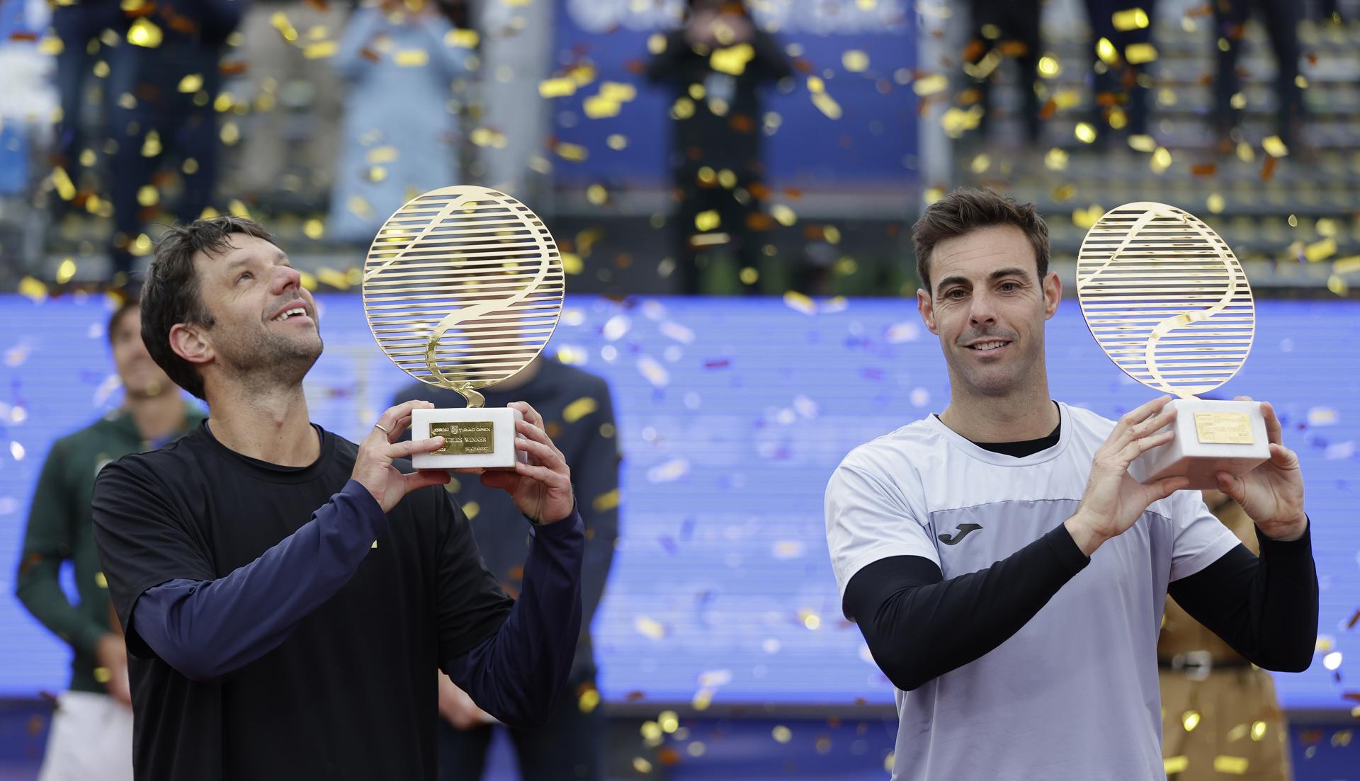 Los tenistas, el español Marcel Granollers y el argentino Horacio Zeballos, celebran trofeo en mano la consecución del título de dobles de la ATP en Bucarest, Rumania. EFE/EPA/Robert Ghement