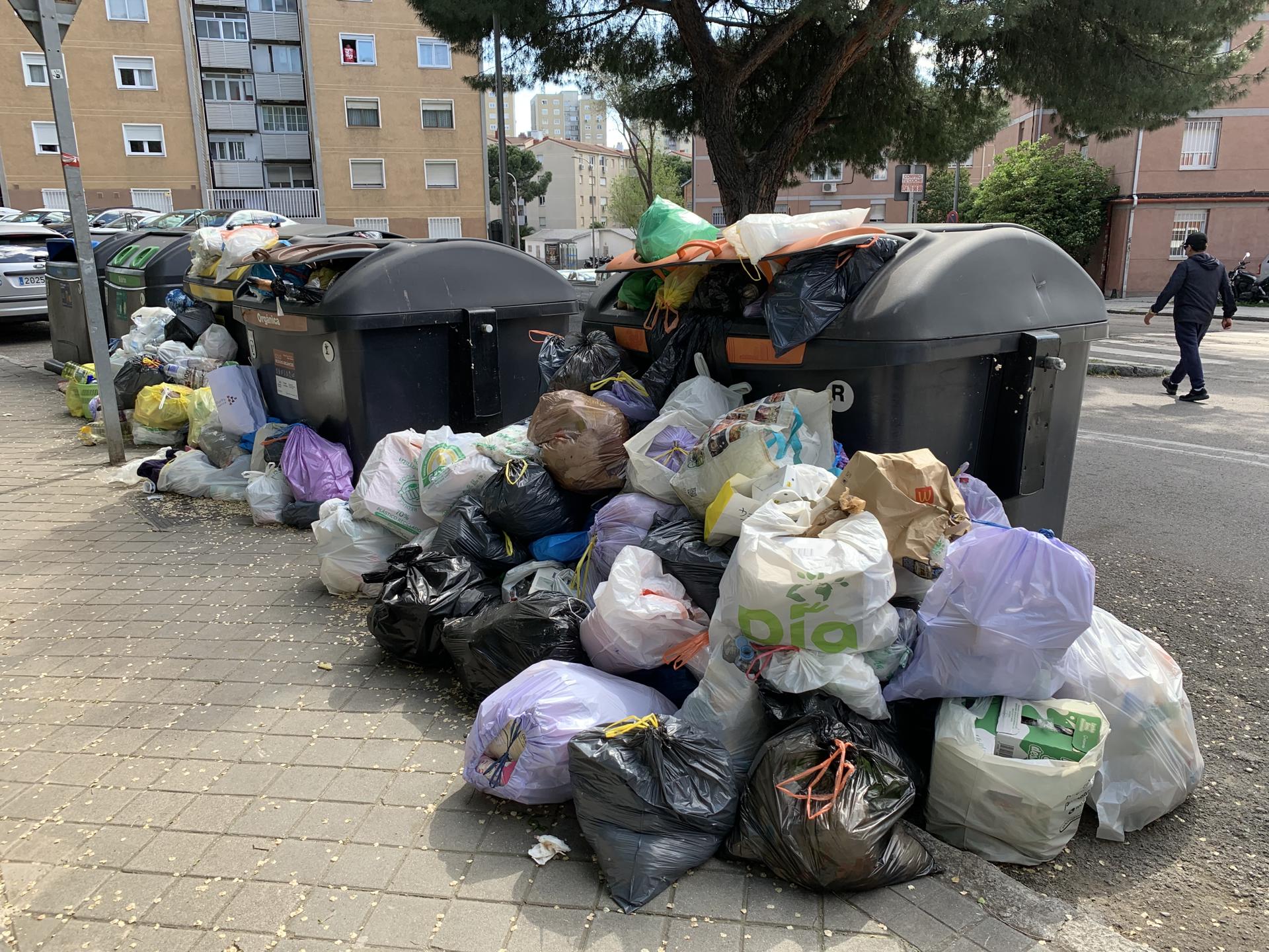 Acumulación de basura esta tarde de sábado en unos contenedores de la calle de Santa Genoveva, en el madrileño barrio de La Elipa. EFE/Paco Pardo