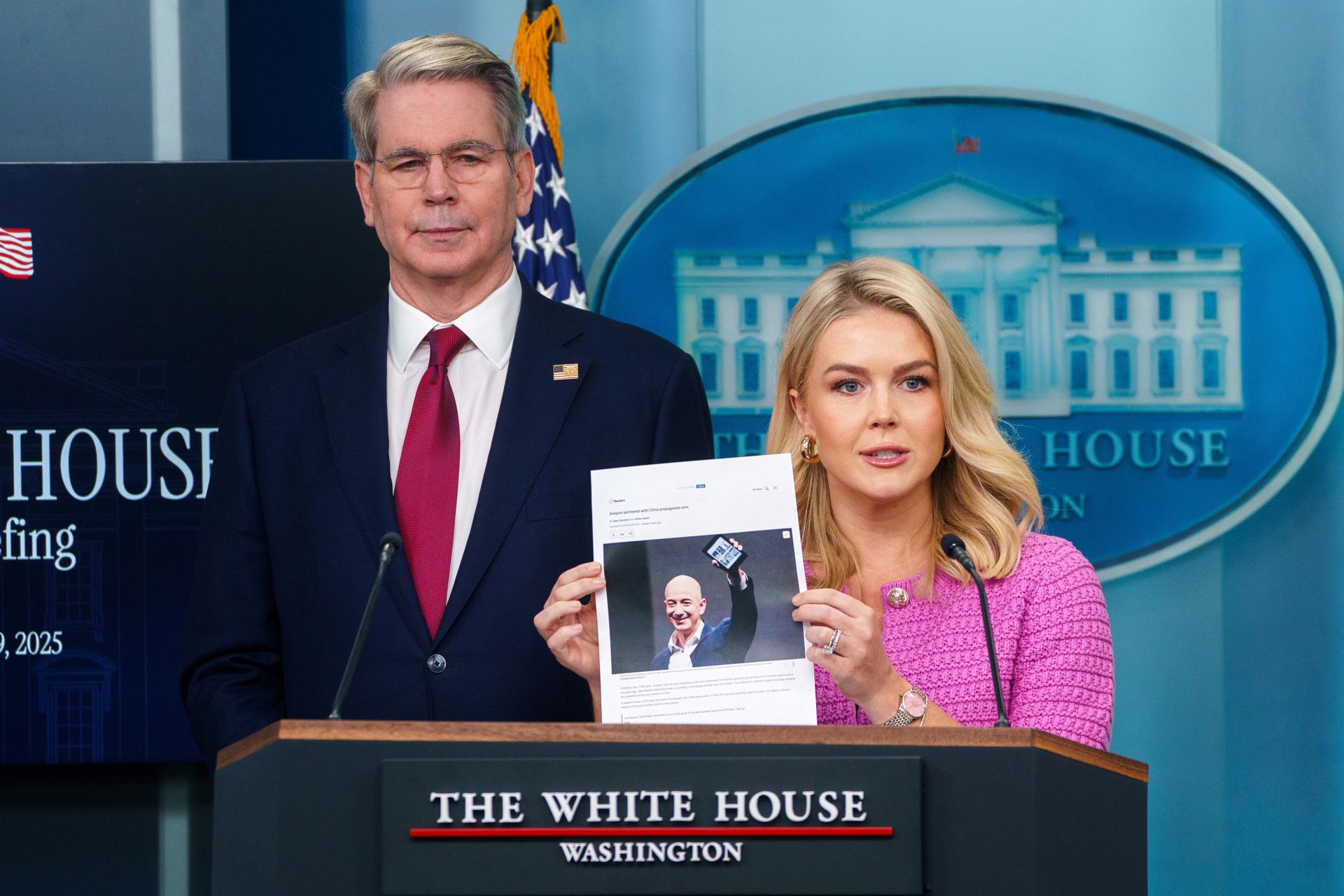 La secretaria de prensa de la Casa Blanca, Karoline Leavitt , sostiene una fotografía del fundador de Amazon, Jeff Bezos, junto al secretario del Tesoro de EE.UU., Scott Bessent, durante una rueda de prensa, en la Casa Blanca, en Washington (EE.UU.). EFE/Will Olíver
