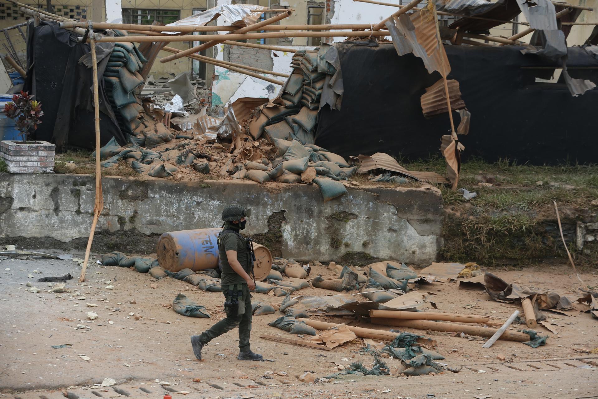 Un integrante de la policía camina frente a una estación de policía afectada por una explosión este jueves, en Mondomo, Cauca (Colombia). EFE/ Ernesto Guzmán
