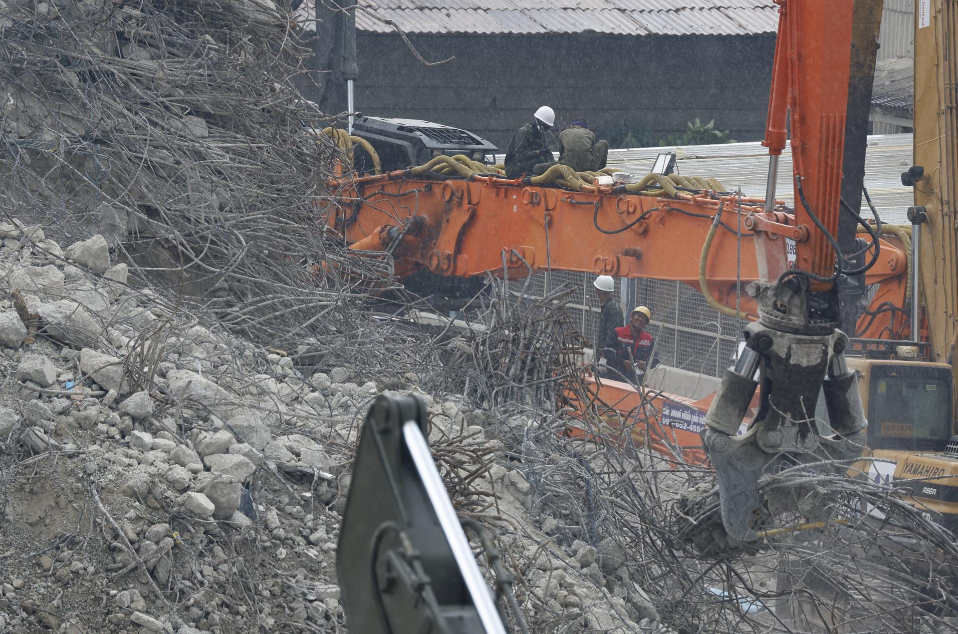 La maquinaria pesada continúa su trabajo en el lugar donde hace dos semanas se derrumbó un edificio en Bangkok.
EFE/EPA/NARONG SANGNAK