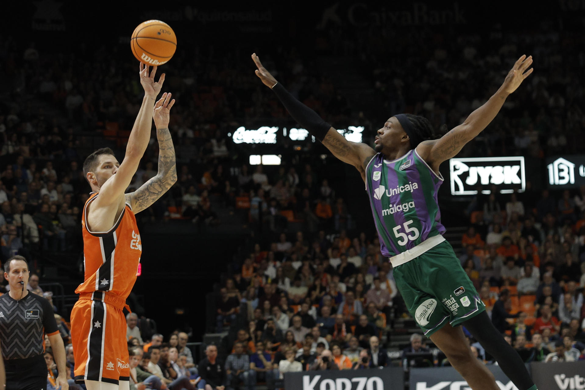 El base del Valencia Stefan Jovic (i) lanza ante Kendrick Perry, de Unicaja, durante el partido de la Liga Endesa de baloncesto que Valencia Basket y Unicaja disputan este domingo en el Pabellón Municipal Fuente de San Luis. EFE/Kai Forsterling