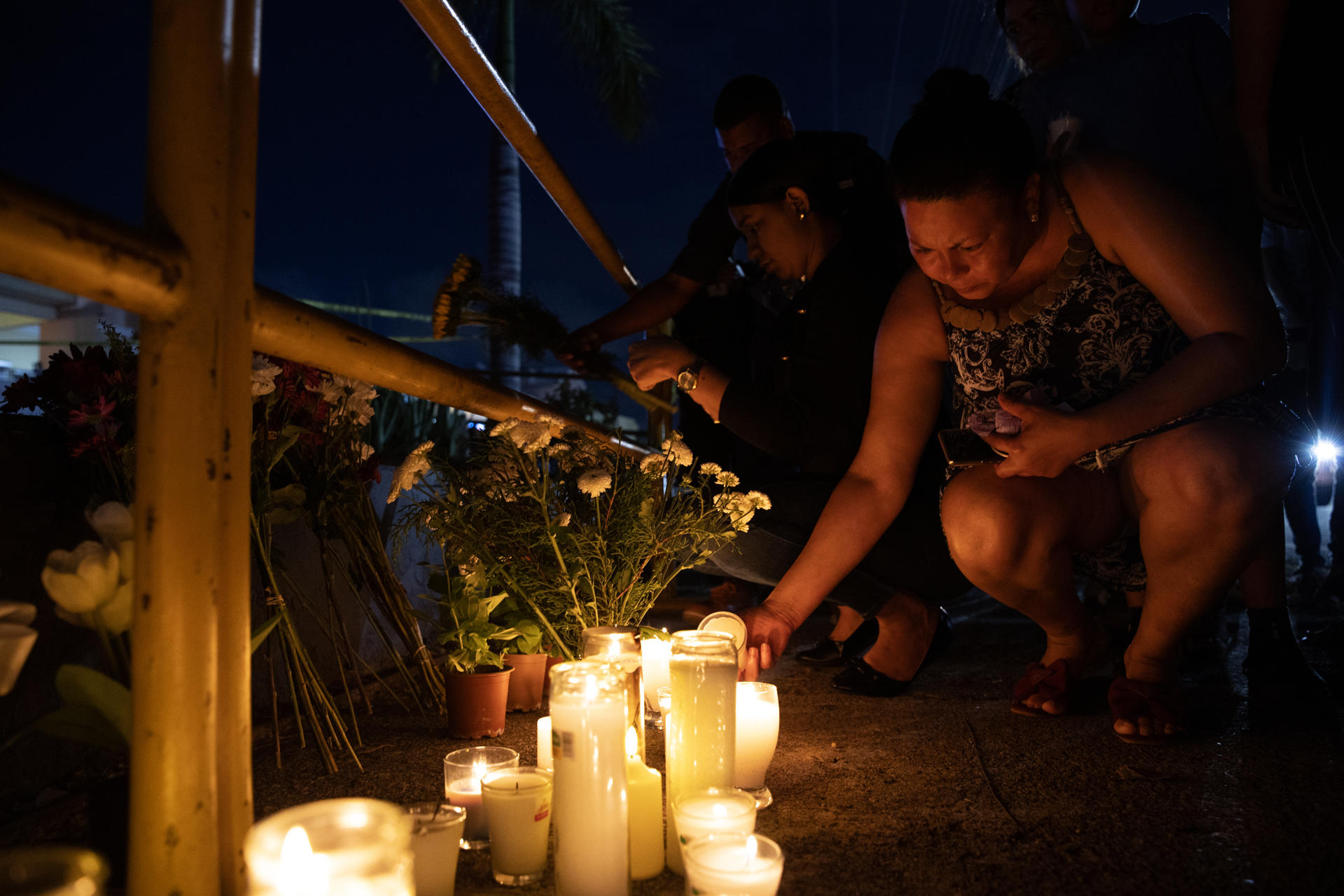 Una mujer enciende una vela durante una velatón este viernes en Santo Domingo (República Dominicana). Decenas de personas encendieron velones, portaron globos y depositaron flores en la parte frontal de la discoteca Jet Set, en Santo Domingo, donde la madrugada del martes pasado el derrumbe del techo causó la muerte de más de 200 personas y dejó heridas a otras 180. EFE/Orlando Barría