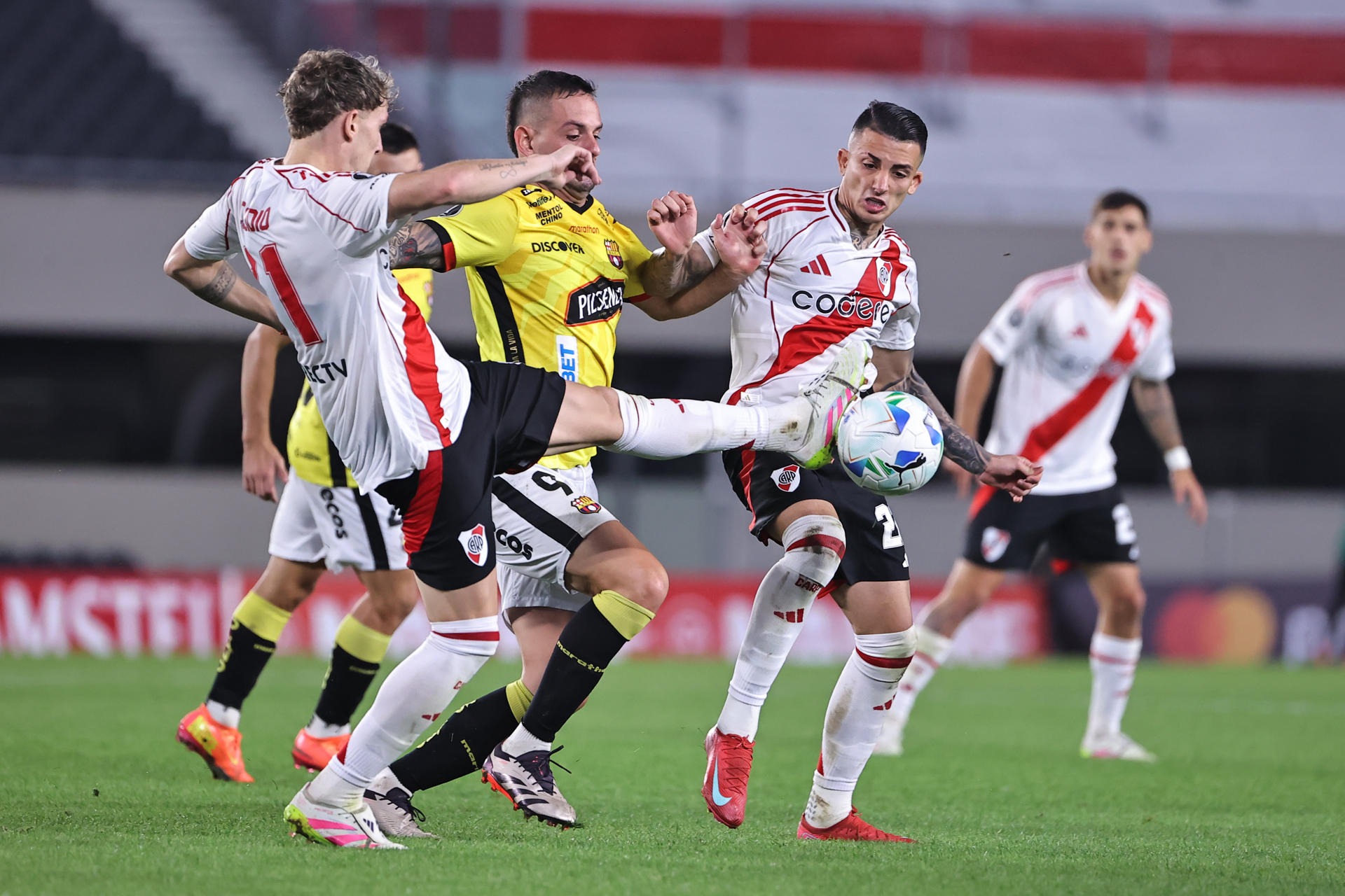 Facundo Colidio (i) de River disputa el balón con Octavio Rivero (c) de Barcelona en un partido de la fase de grupos de la Copa Libertadores. EFE/ Juan Ignacio Roncoroni