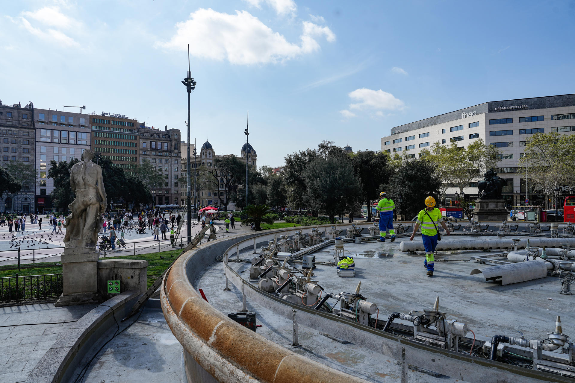 En la imagen unos operarios realizan tareas de reparación en las fuentes de Plaza Catalunya.EFE/ Enric Fontcuberta