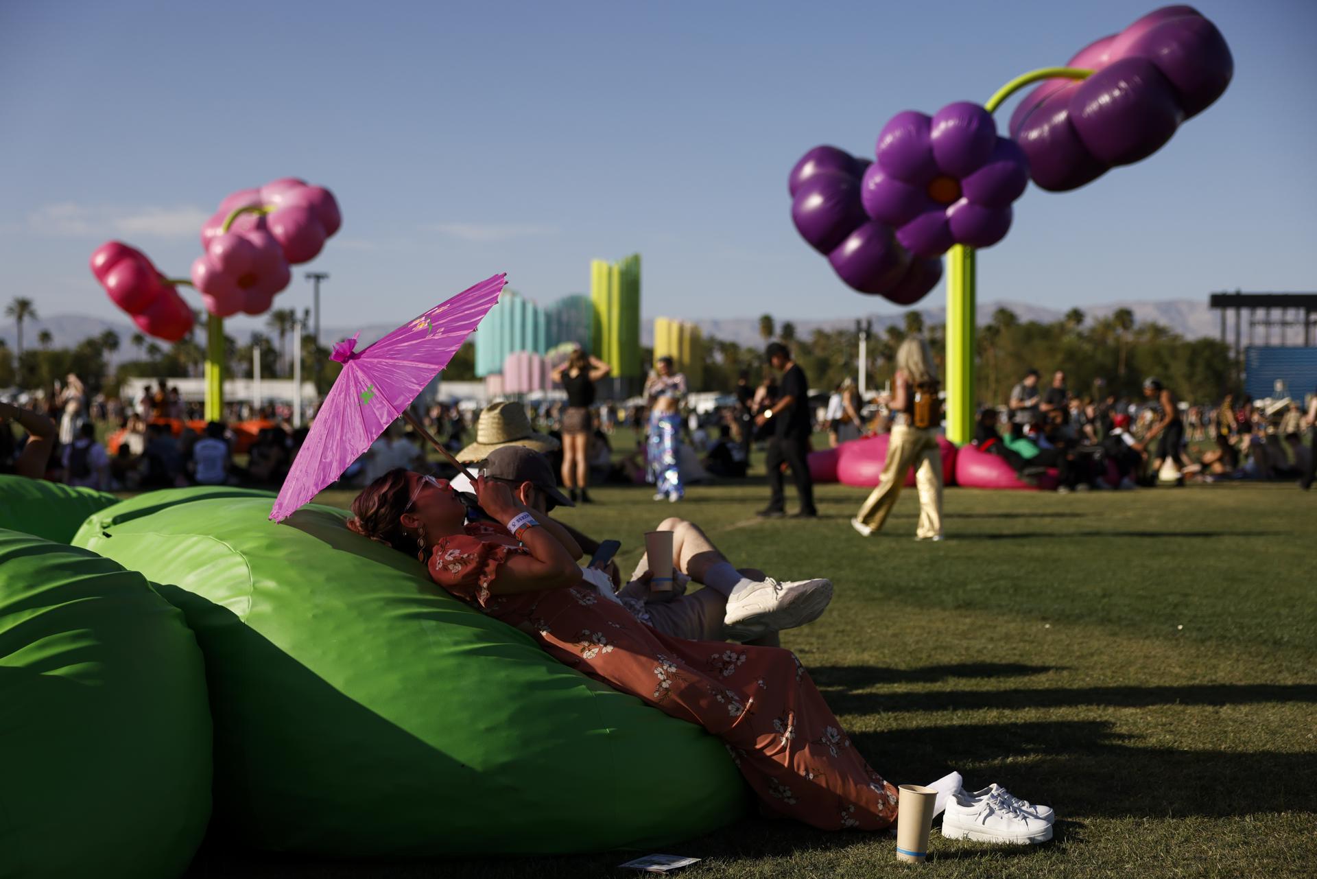 Asistentes se sientan en una zona con sombra mientras la temperatura alcanza iveles altos durante el Festival de Música y Artes del Valle de Coachella en Indio, California. EFE/EPA/CAROLINE BREHMAN