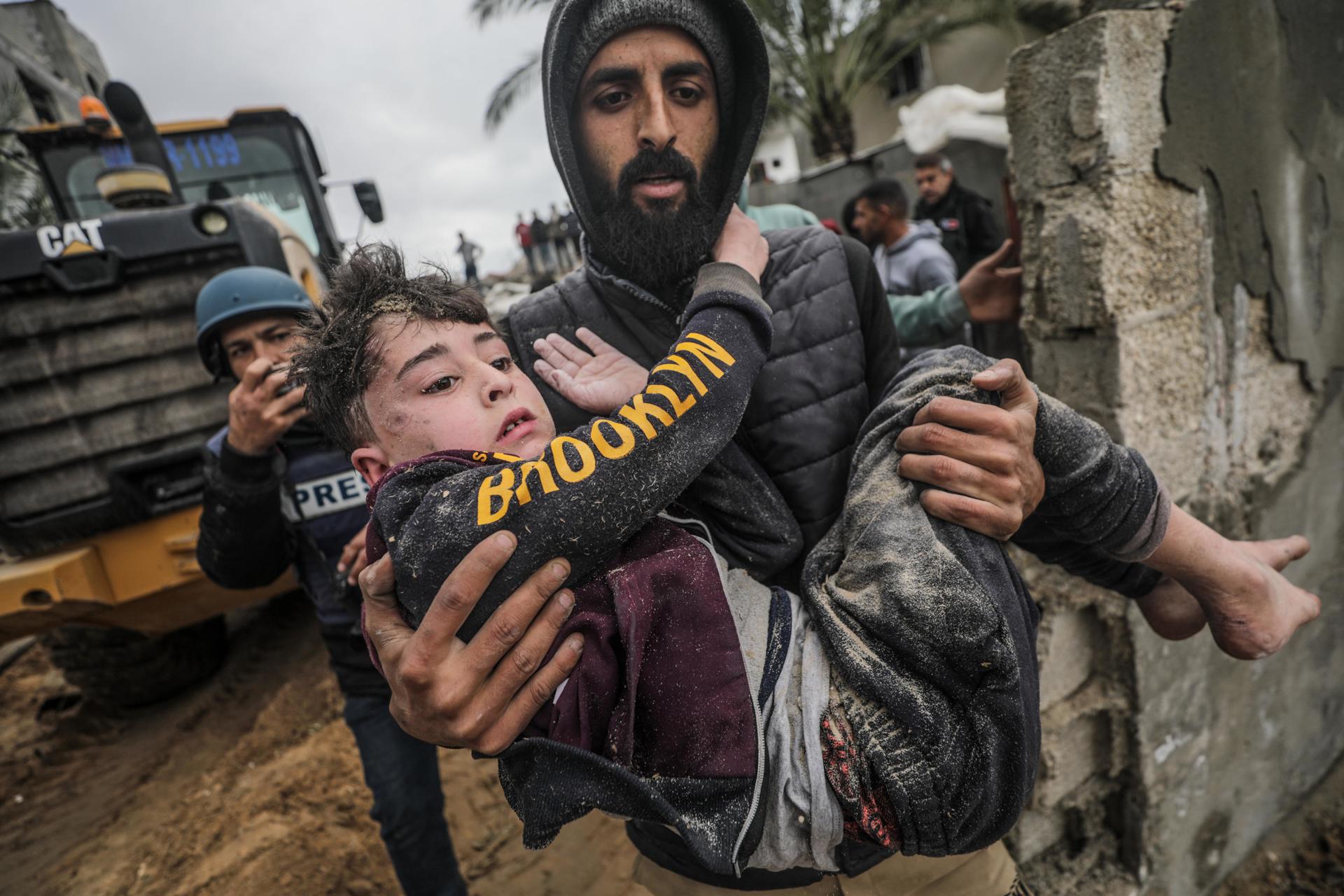 Los palestinos recuperan a un niño herido de debajo de los escombros de su casa familiar destruida tras un ataque aéreo israelí en el sur de la ciudad de Deir Al Balah, en el sur de la Franja de Gaza, el 7 de marzo de 2024.EFE/EPA/MOHAMMED SABLE