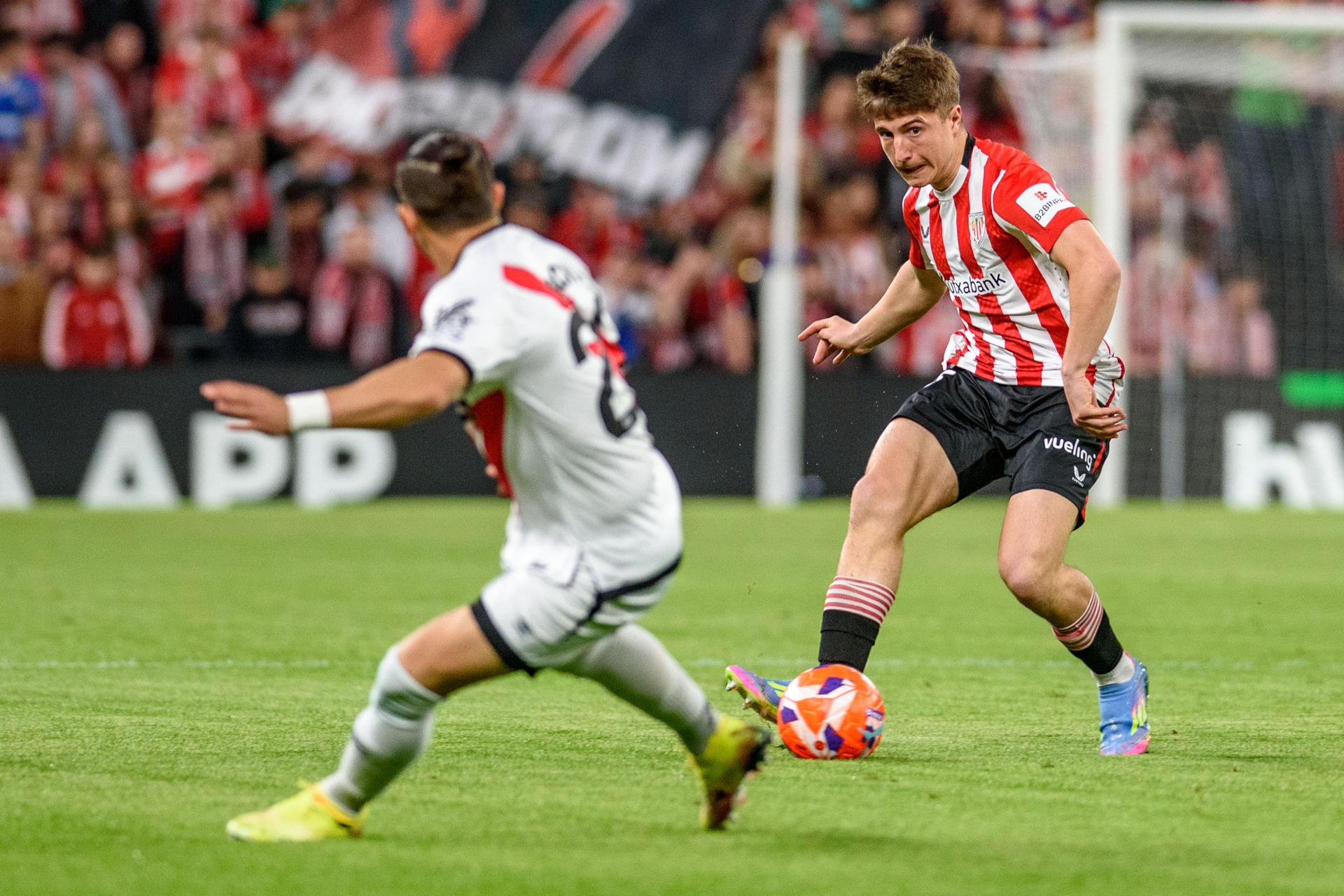 El centrocampista del Athletic Club de Bilbao Mikel Jauregizar (d) juega el balón ante el defensa uruguayo del Rayo Vallecano Pacha Espino (i), durante el partido de la jornada 31 de LaLiga EA Sports que disputaron Athletic Club de Bilbao y Rayo Vallecano en el estadio de San Mamés, en Bilbao. EFE/Javier Zorrilla